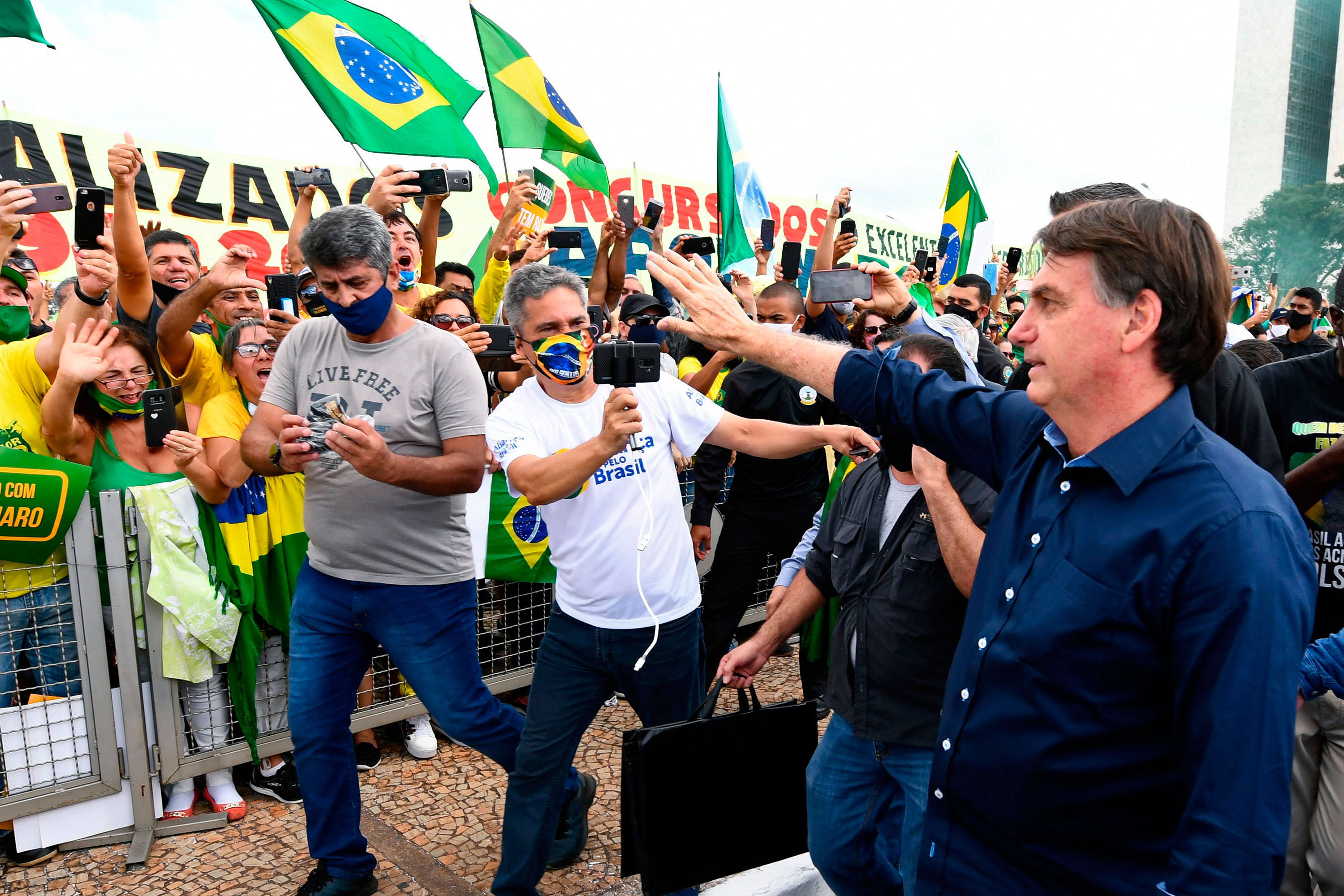 Brazil's President Jair Bolsonaro greets supporters upon arrival at Planalto Palace in Brasilia, on May 24.