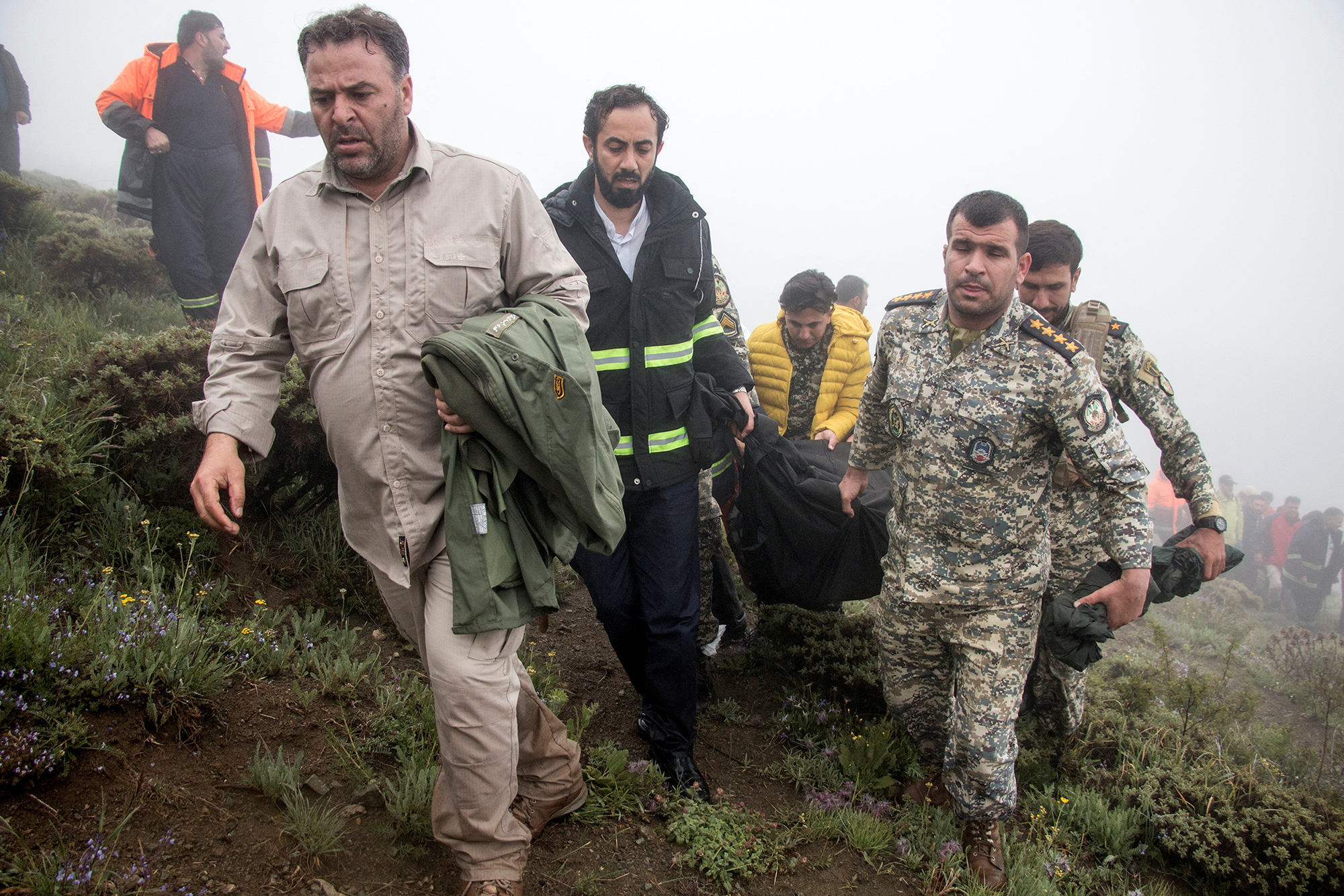 A rescue team carries a body following a helicopter crash carrying Iran's President Ebrahim Raisi, in Varzaqan, Iran, on May 20.