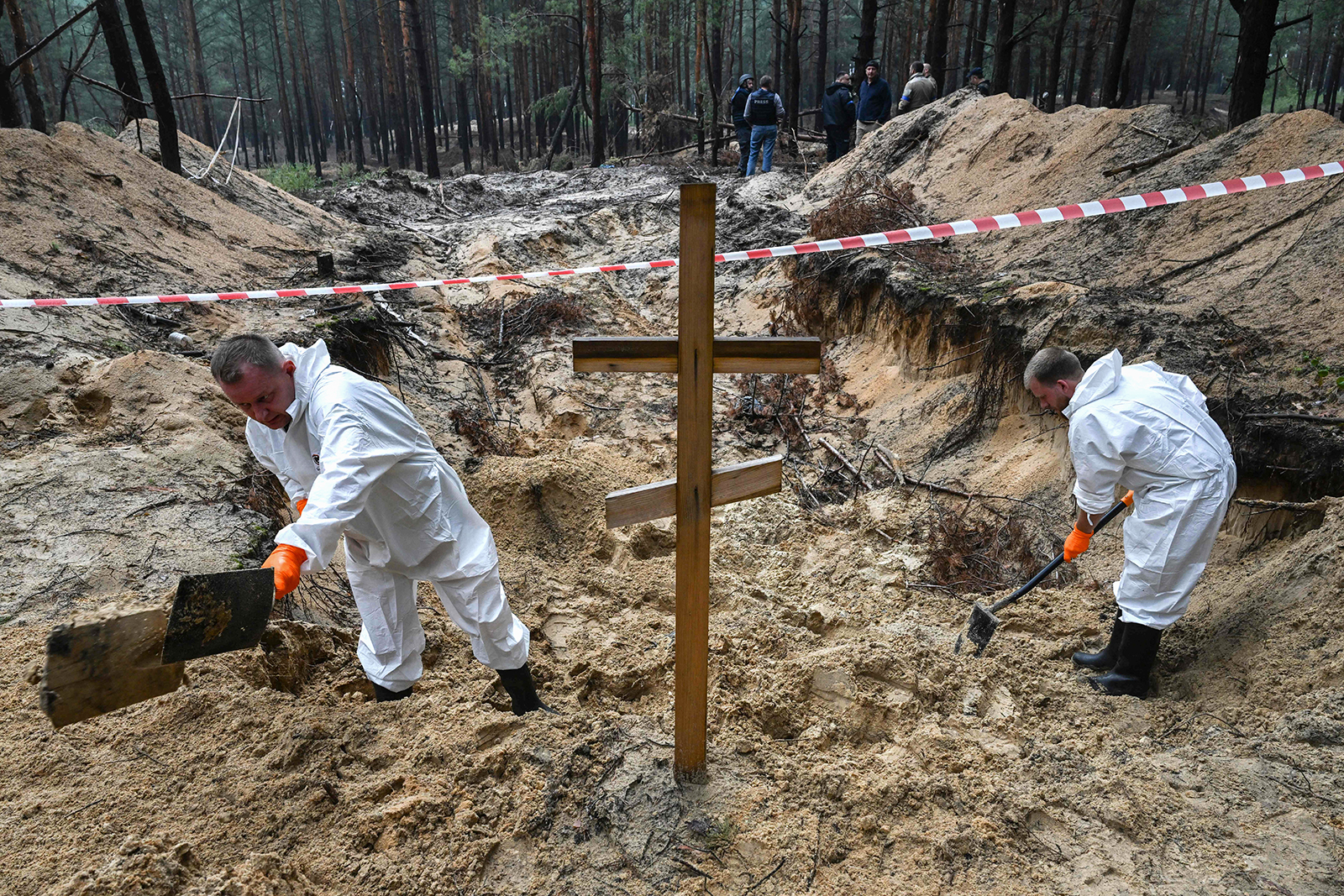 Forensic technicians dig near a cross in a forest on the outskirts of Izyum, eastern Ukraine on Friday.