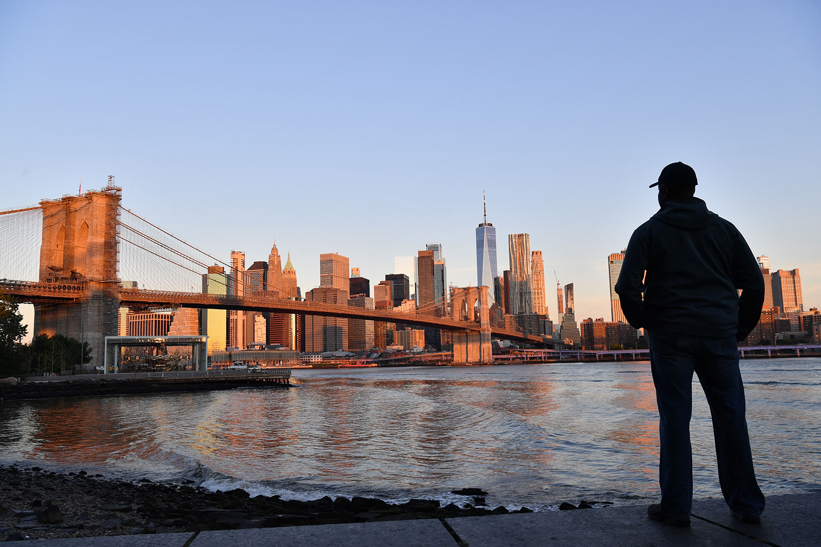 A man looks out at the early morning skyline on the 20th anniversary of the 9/11 attacks on the World Trade Center in Manhattan in New York, on September 11, 2021. 
