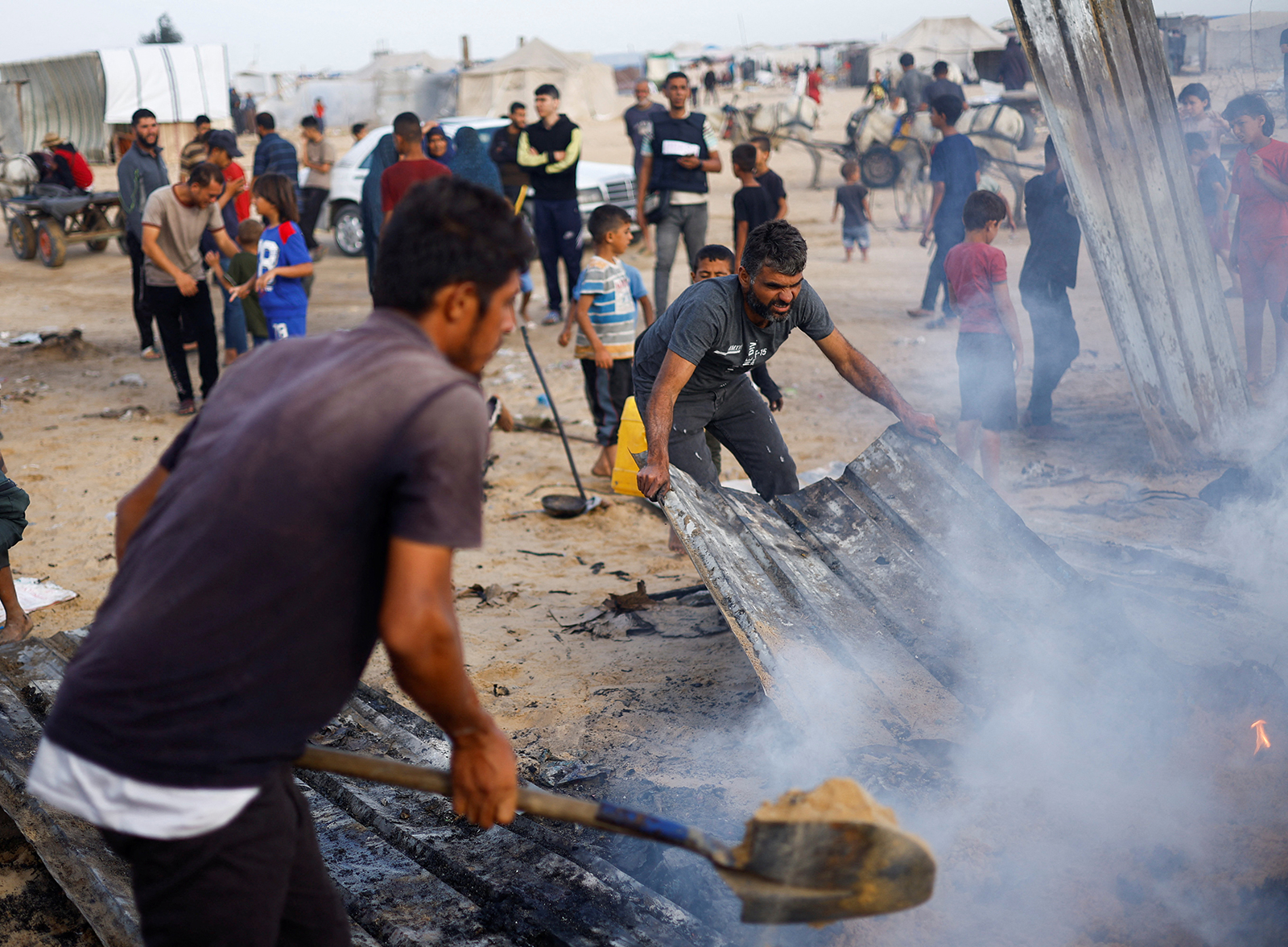 Palestinians put out a fire at the site of an Israeli strike on an area designated for displaced people, in Rafah, Gaza, on May 27.