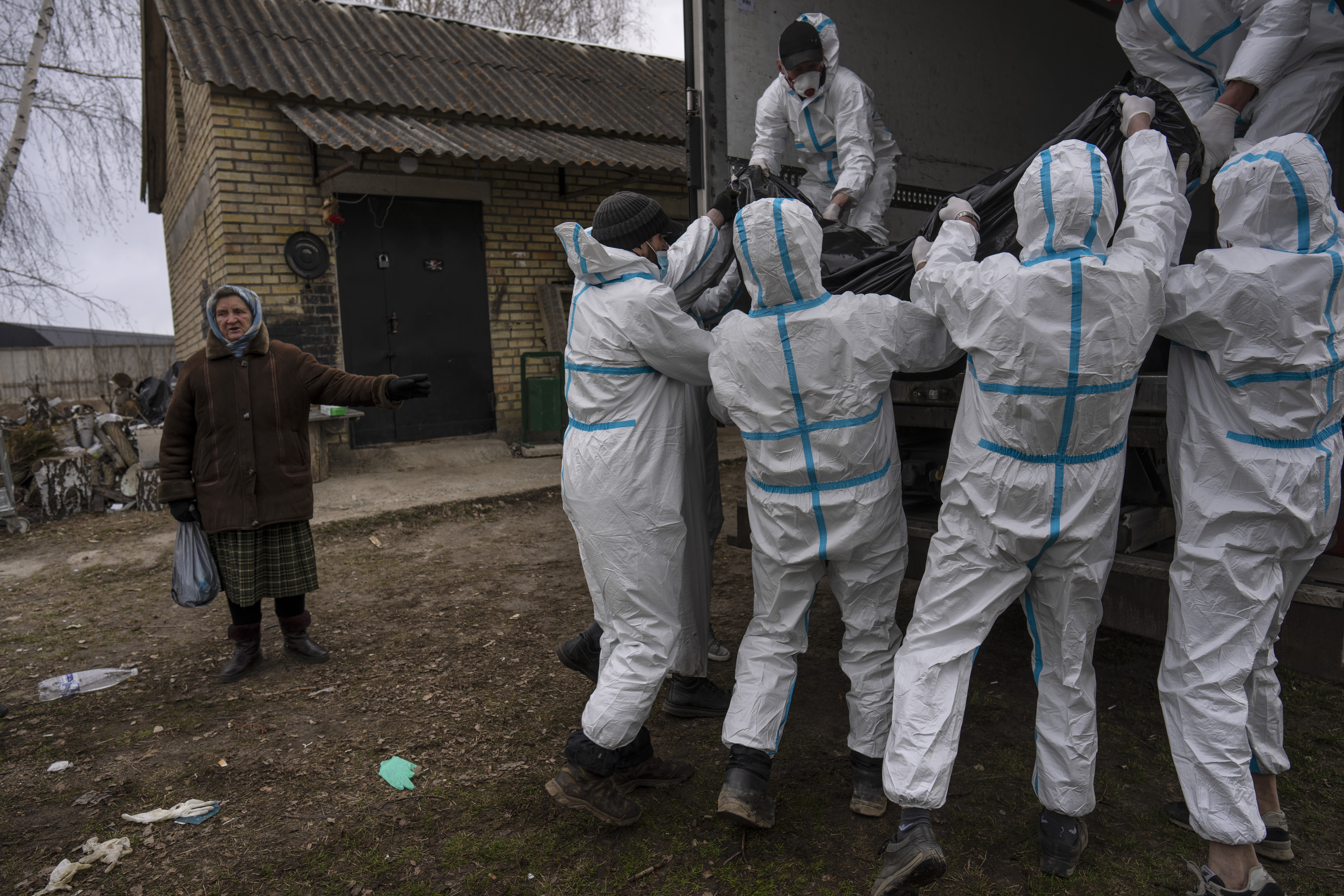 Nadiya Trubchaninova, 70, observes volunteers as they load a body bag containing a civilian killed by Russian soldiers into a truck, in Bucha, on the outskirts of Kyiv, Ukraine, on April 12. 