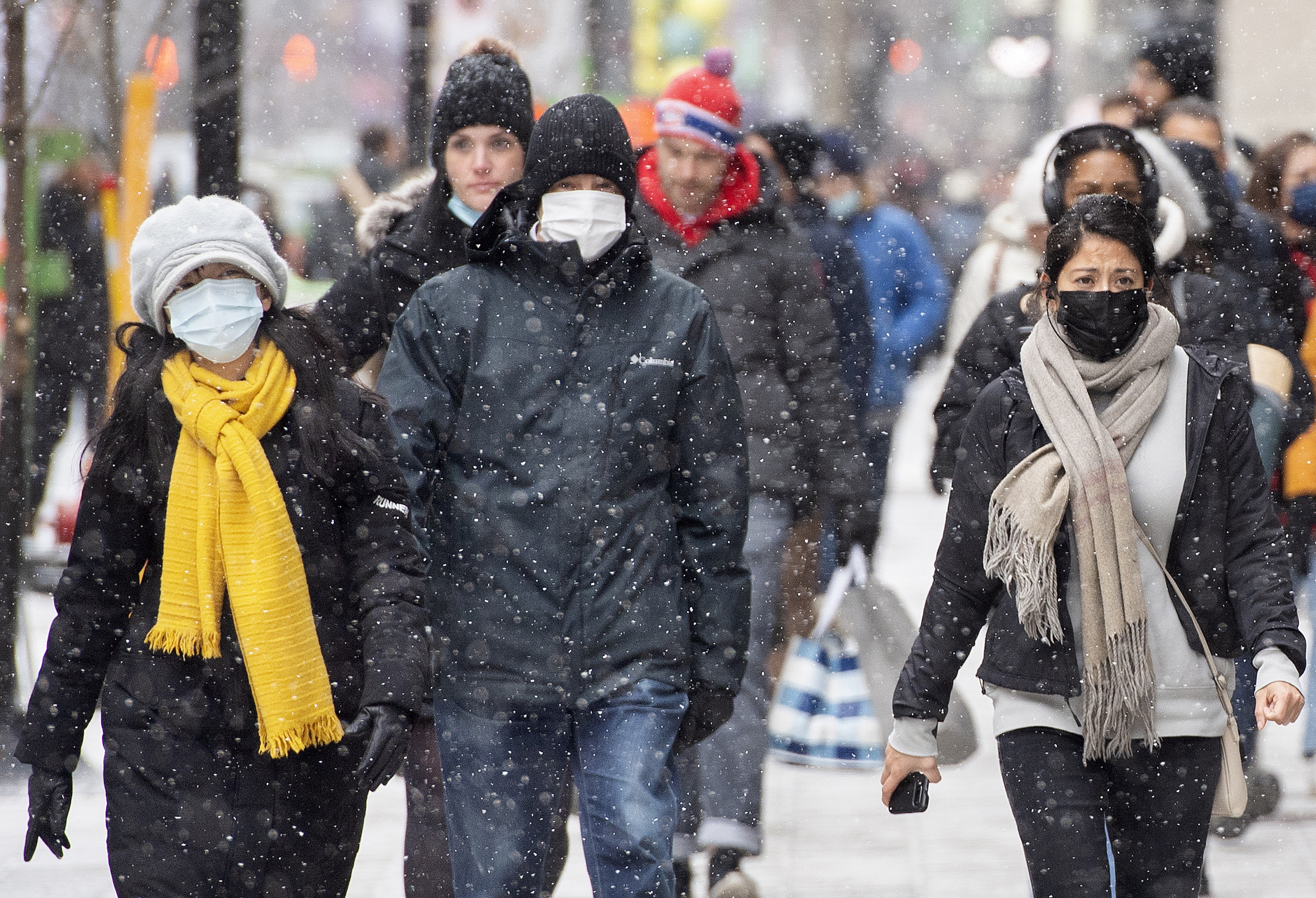 People wear face masks due to the coronavirus pandemic as they walk along Ste-Catherine Street in Montreal on December 4, 2021. (Graham Hughes/The Canadian Press/AP)