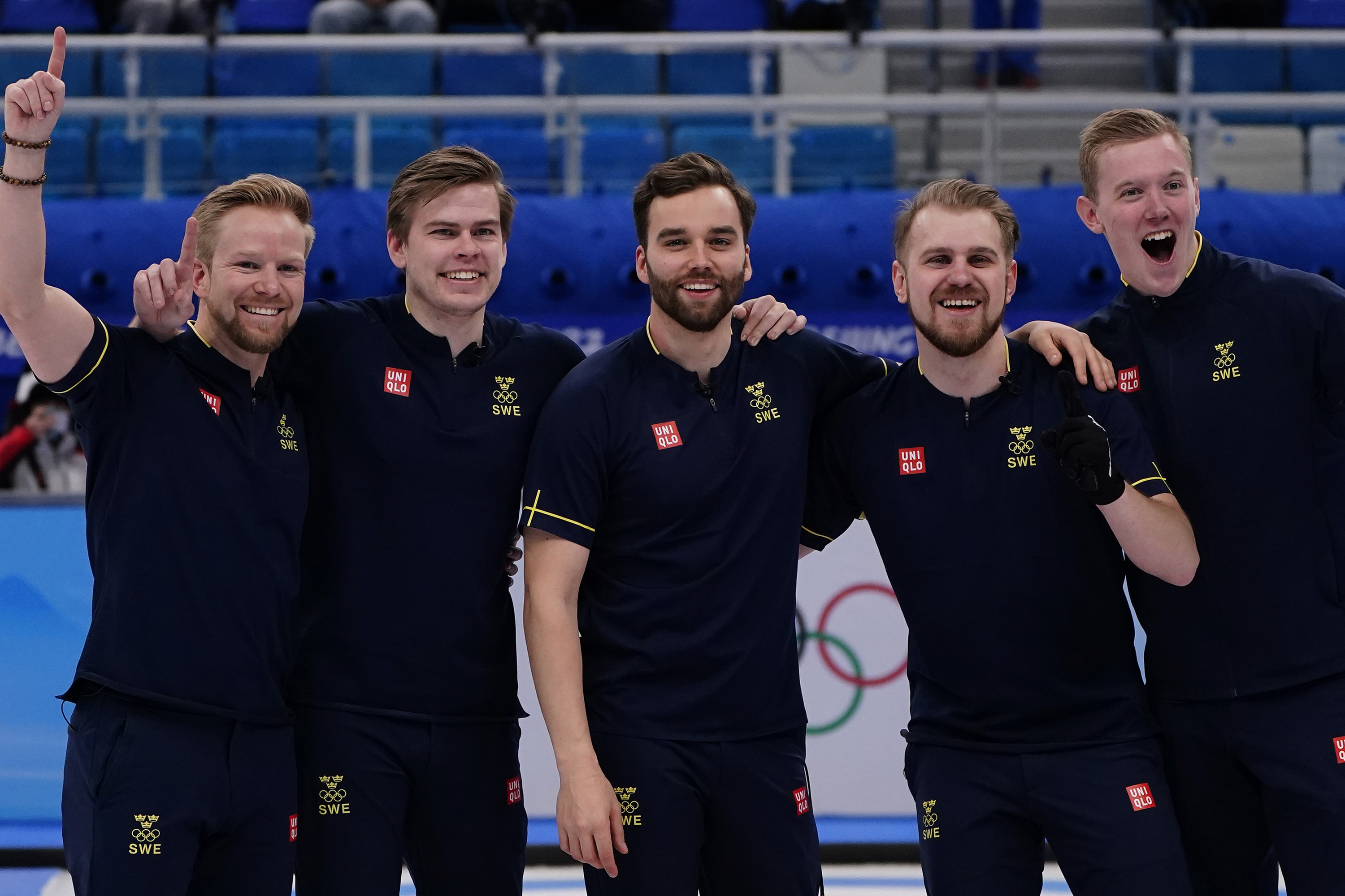 Team Sweden celebrates their win in the men's curling final match between Britain and Sweden on Saturday.