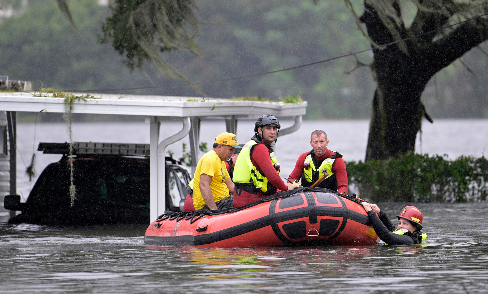 First responders with Orange County Fire Rescue use an inflatable boat to rescue a resident from a home in Orlando on Thursday.