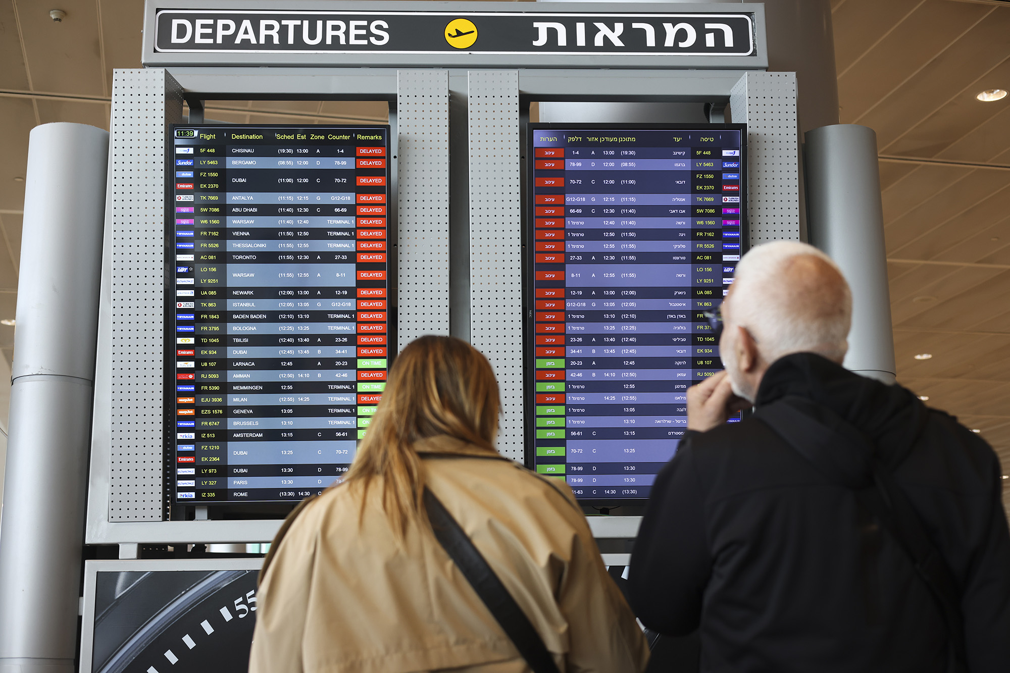 Passengers look at the monitor displaying delayed flights at Ben Gurion airport, near Tel Aviv, Israel, on March 27.