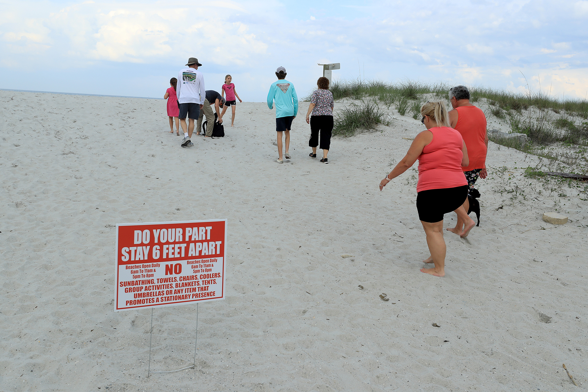 People walk up a public access to the beach on Sunday, April 19, in Jacksonville Beach, Florida. 