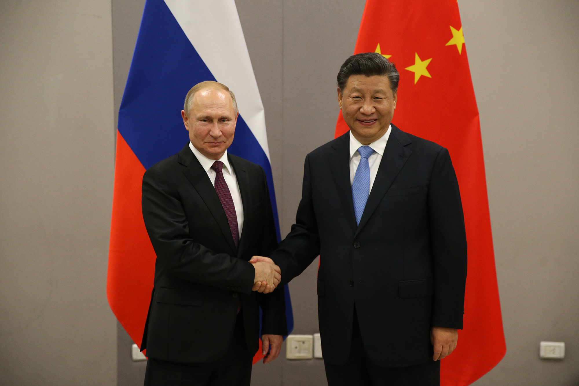 Russian President Vladimir Putin, left, greets Chinese President Xi Jinping during their bilateral meeting on November 13, 2019 in Brasilia, Brazil. 