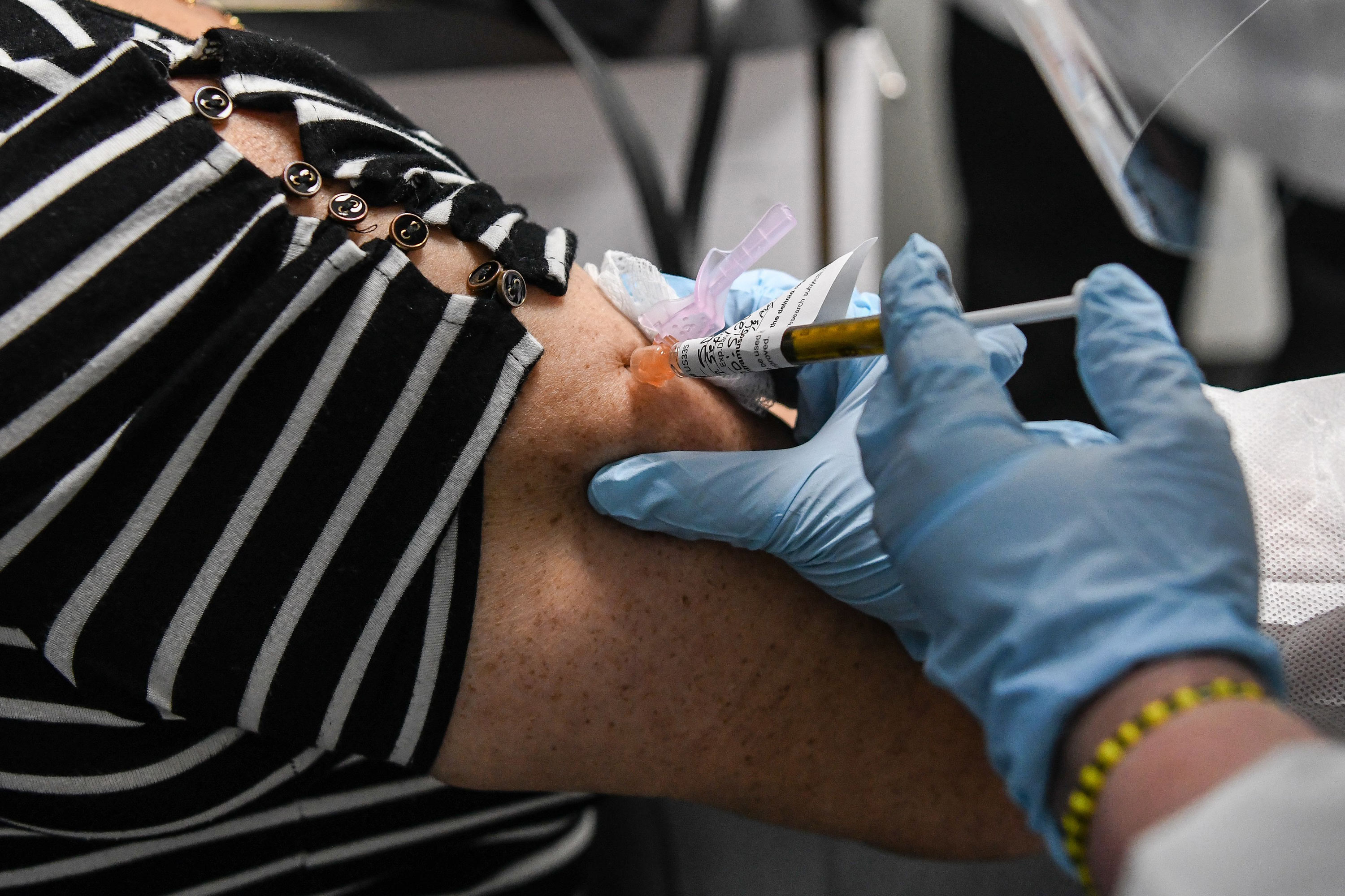 A person receives an injection during a clinical trial for a COVID-19 vaccine at the Research Centers of America in Hollywood, Florida, on August 13.