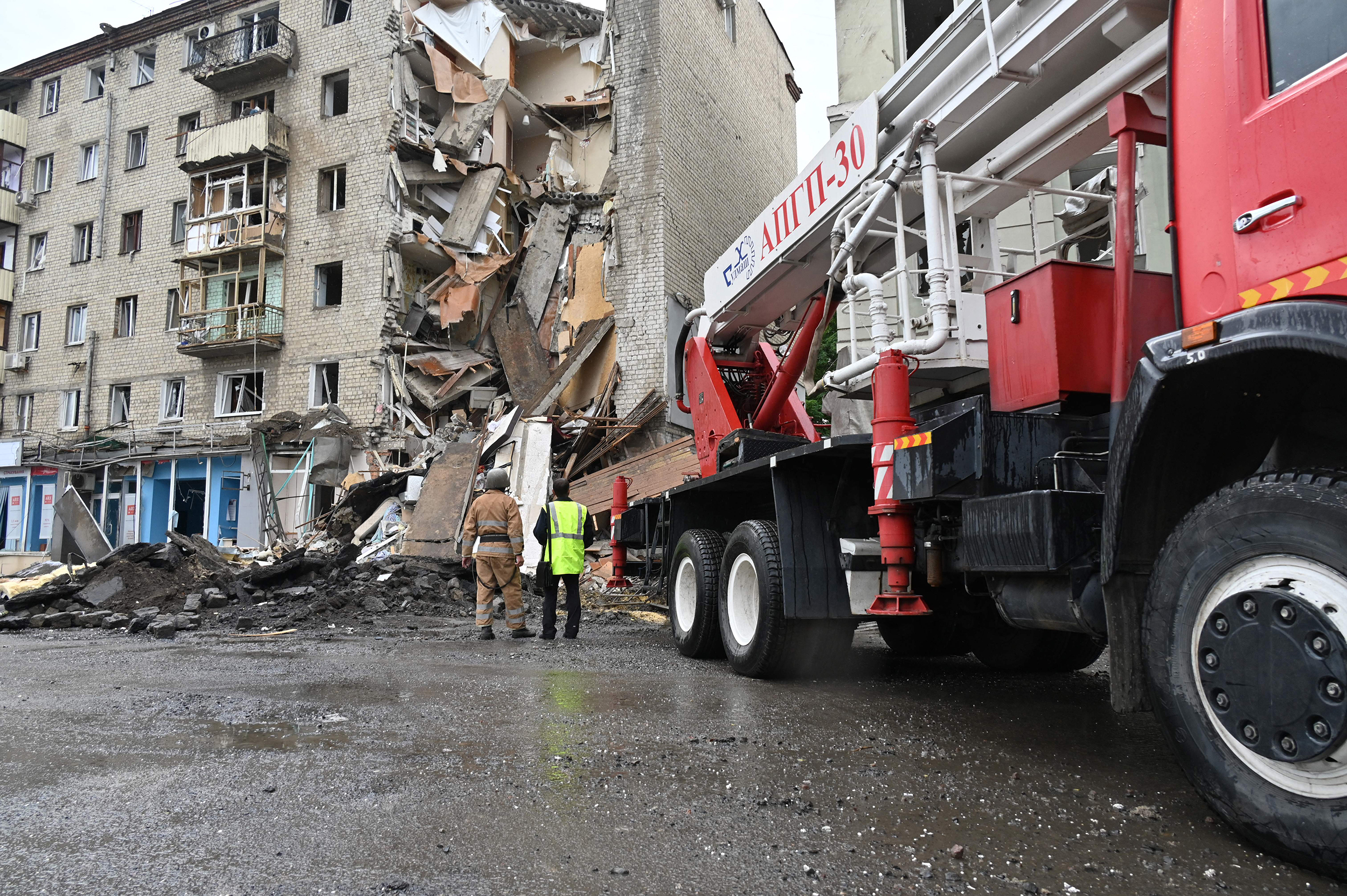 Ukrainian rescuers work outside a building partially destroyed after a missile strike in Kharkiv, Ukraine, on July 11.