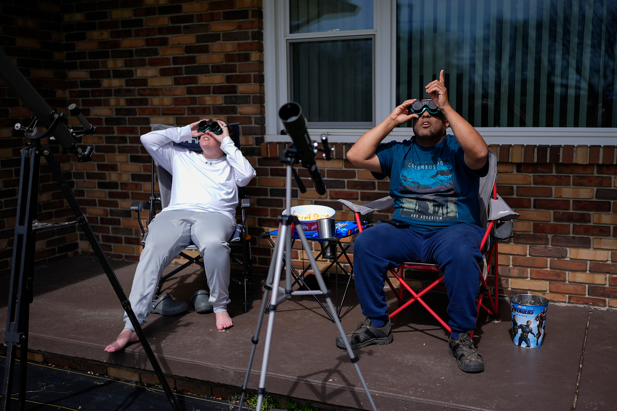 Melissa, left, and Michael Richards watch through solar goggles as the moon partially covers the sun during the total solar eclipse, in Wooster, Ohio.