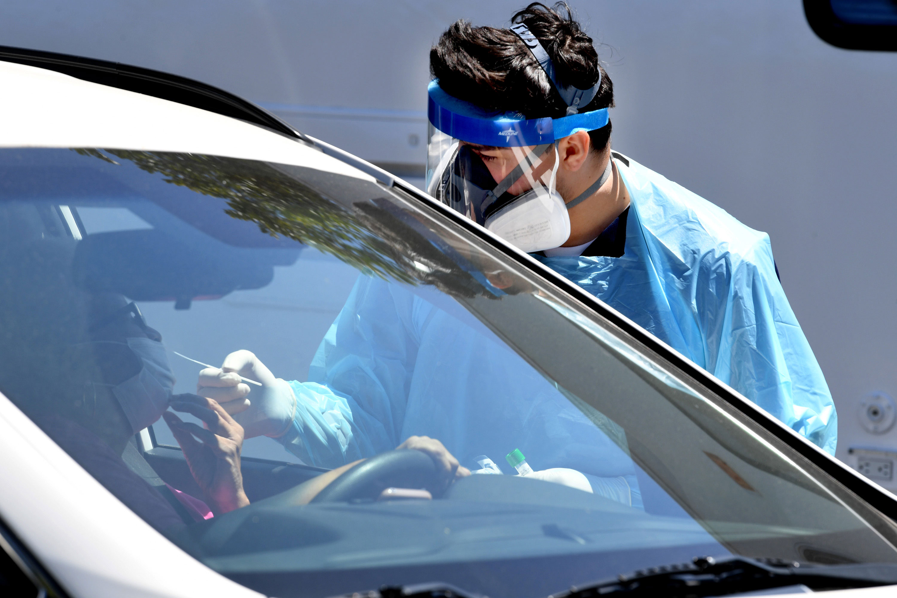 A worker administers a coronavirus test swab at a drive-thru testing site on April 24 in Los Angeles, California.