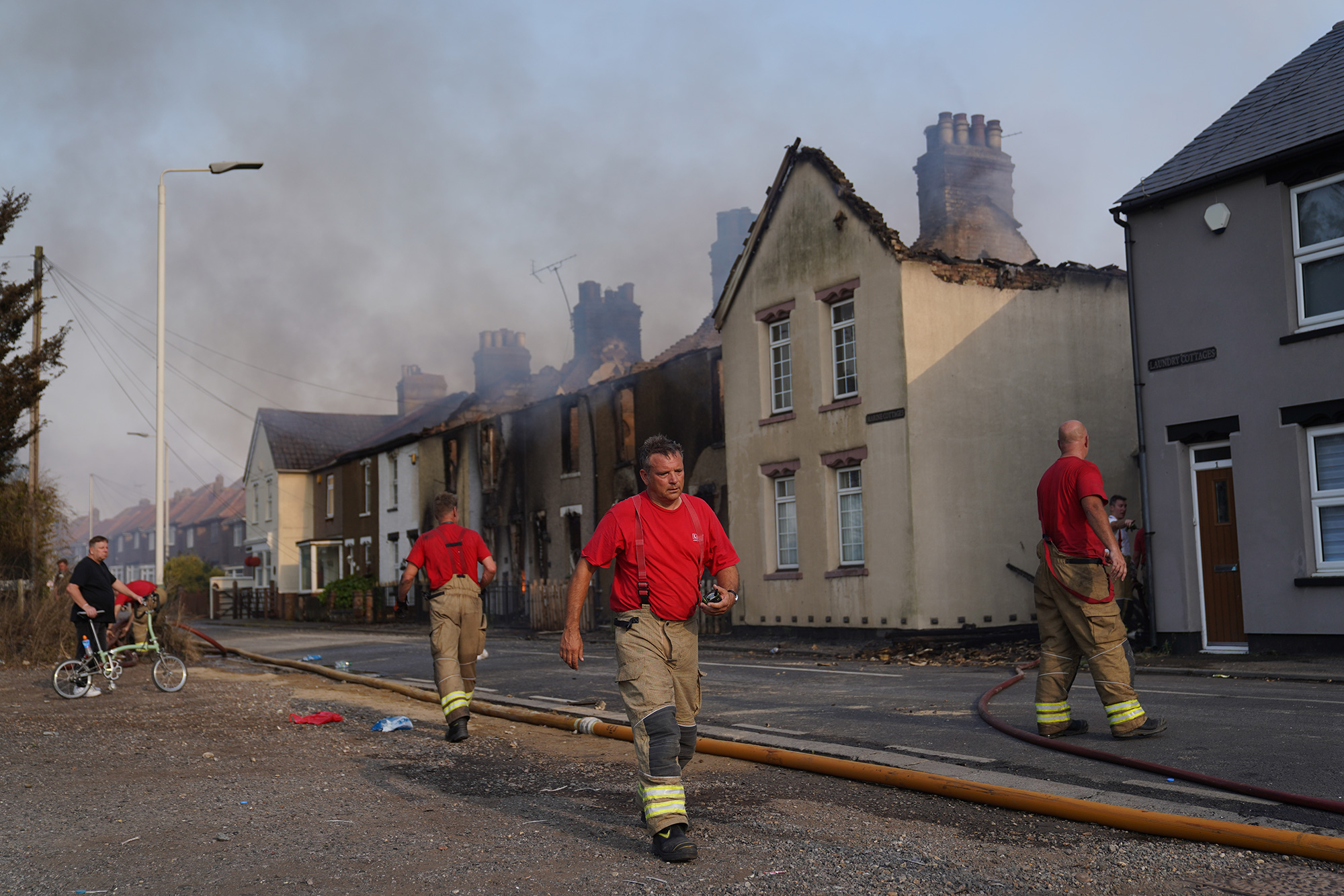 Firefighters at the scene of a blaze in the village of Wennington, located in east London, England, on Tuesday, July 19.