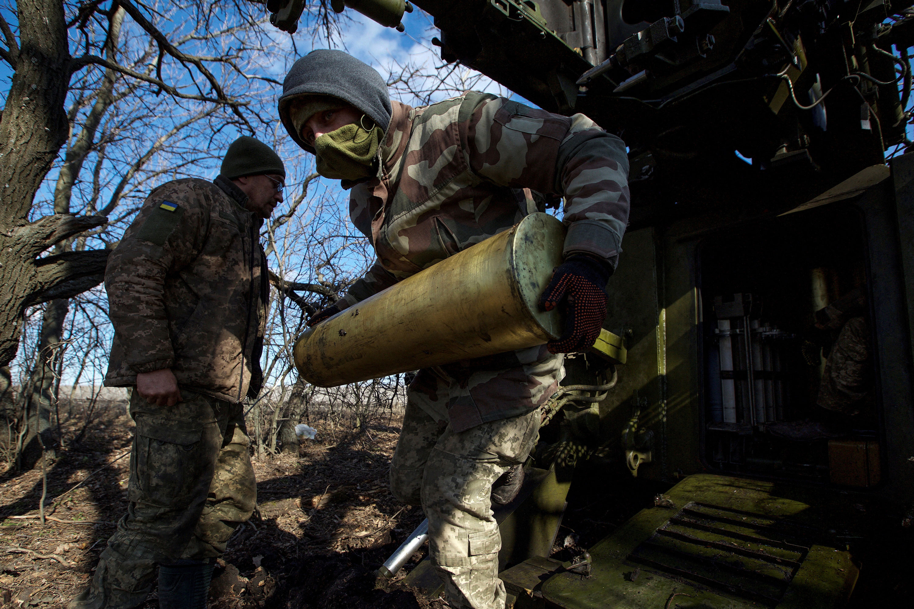 A Ukrainian serviceman carries a shell for firing towards Russian positions outside the town of Bakhmut, Ukraine, on March 5.