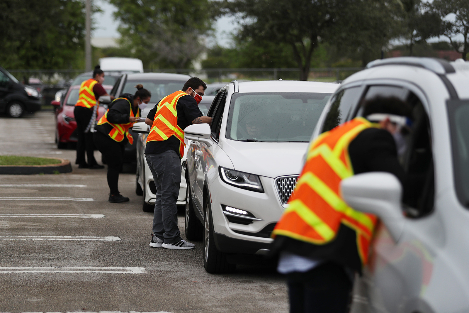 Poll workers receive Vote-by-Mail ballots in a drive thru system setup at the Election Headquarters polling station on October 19, in Doral, Florida. 