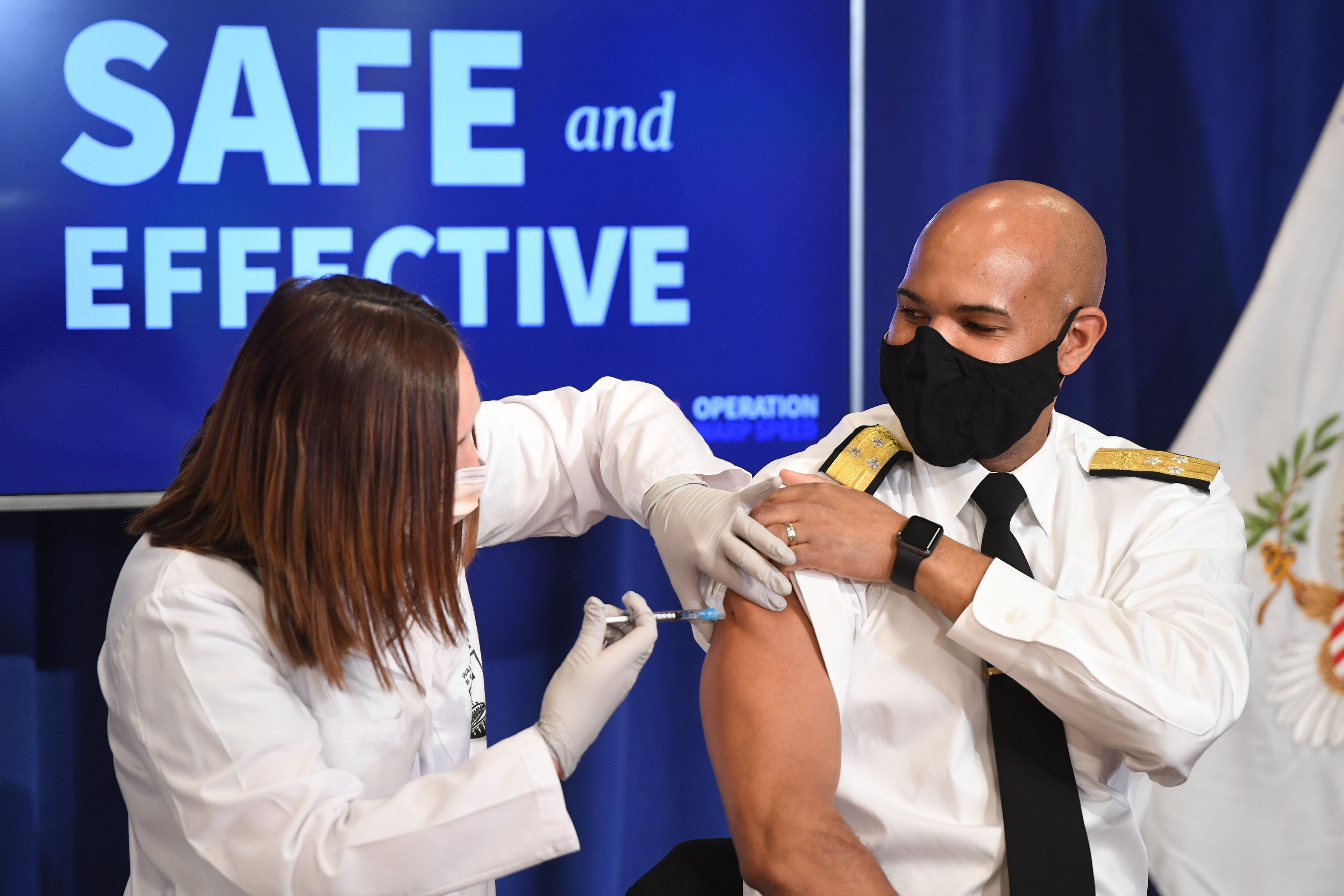 US Surgeon General Jerome Adams receives the COVID-19 vaccine at the Eisenhower Executive Office Building in Washington, DC, on Friday, December 18.