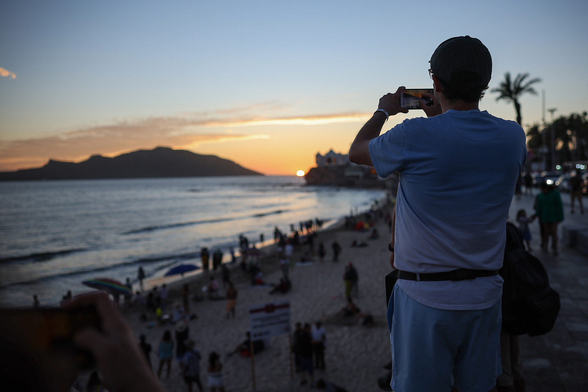 A man takes photos of the sunset ahead of Monday's eclipse in Mazatlán, Mexico, on April 07.