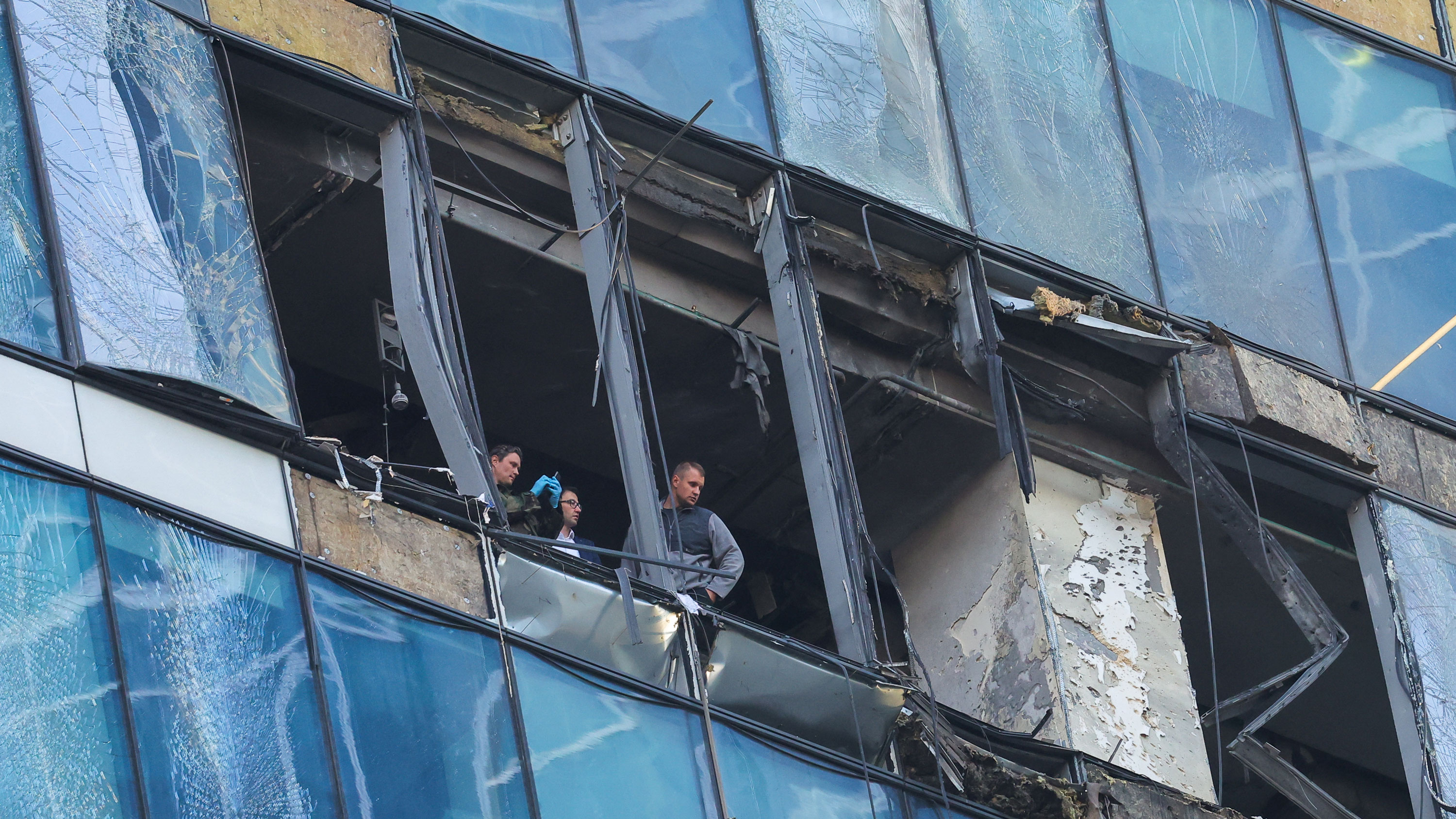 Members of security services investigate a damaged office building in the Moscow City following a reported Ukrainian drone attack in Moscow, Russia, on August 1, 2023.
