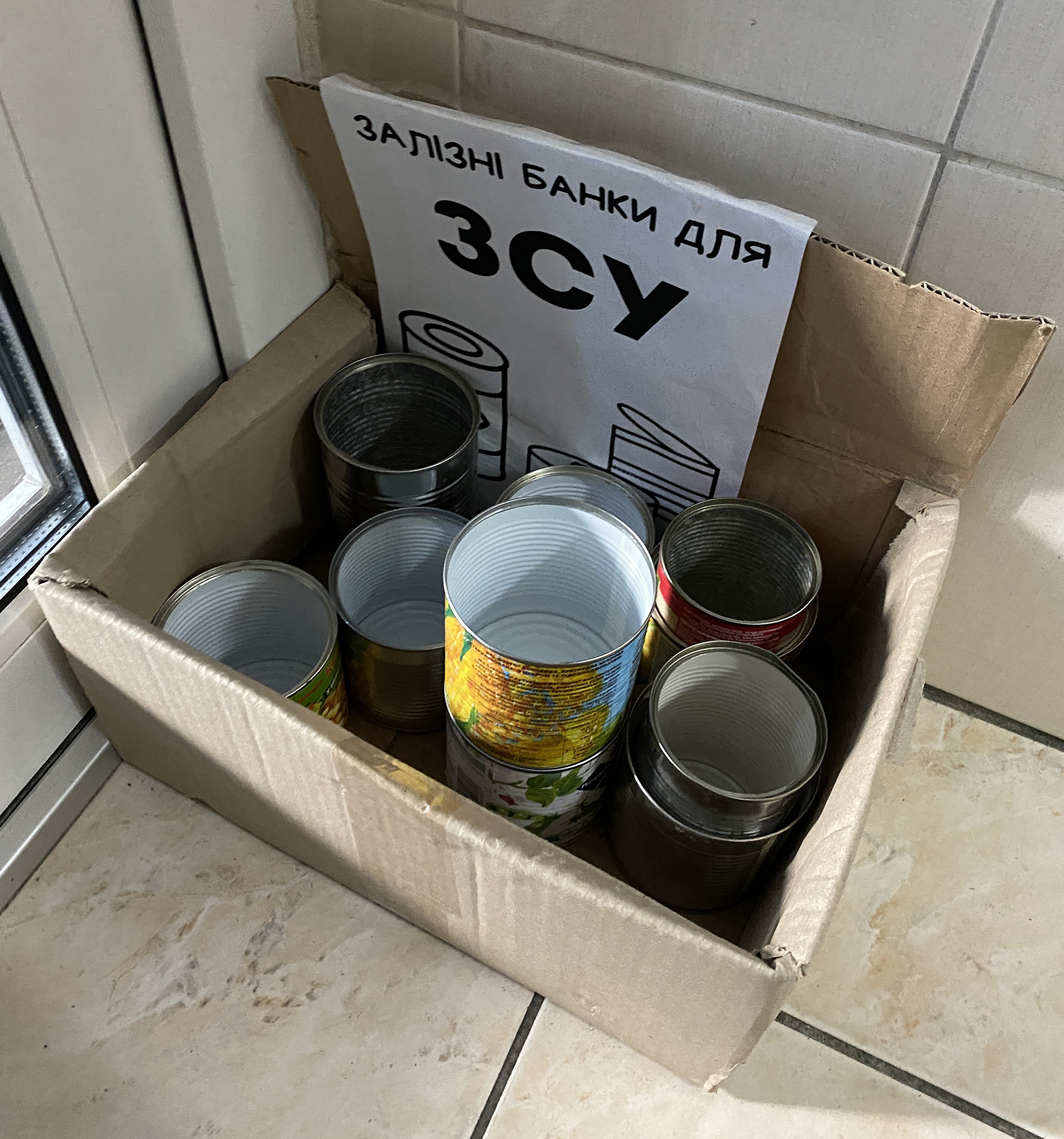 A collection point for tins; the sign says “Cans for AFU” (Armed Forces of Ukraine)