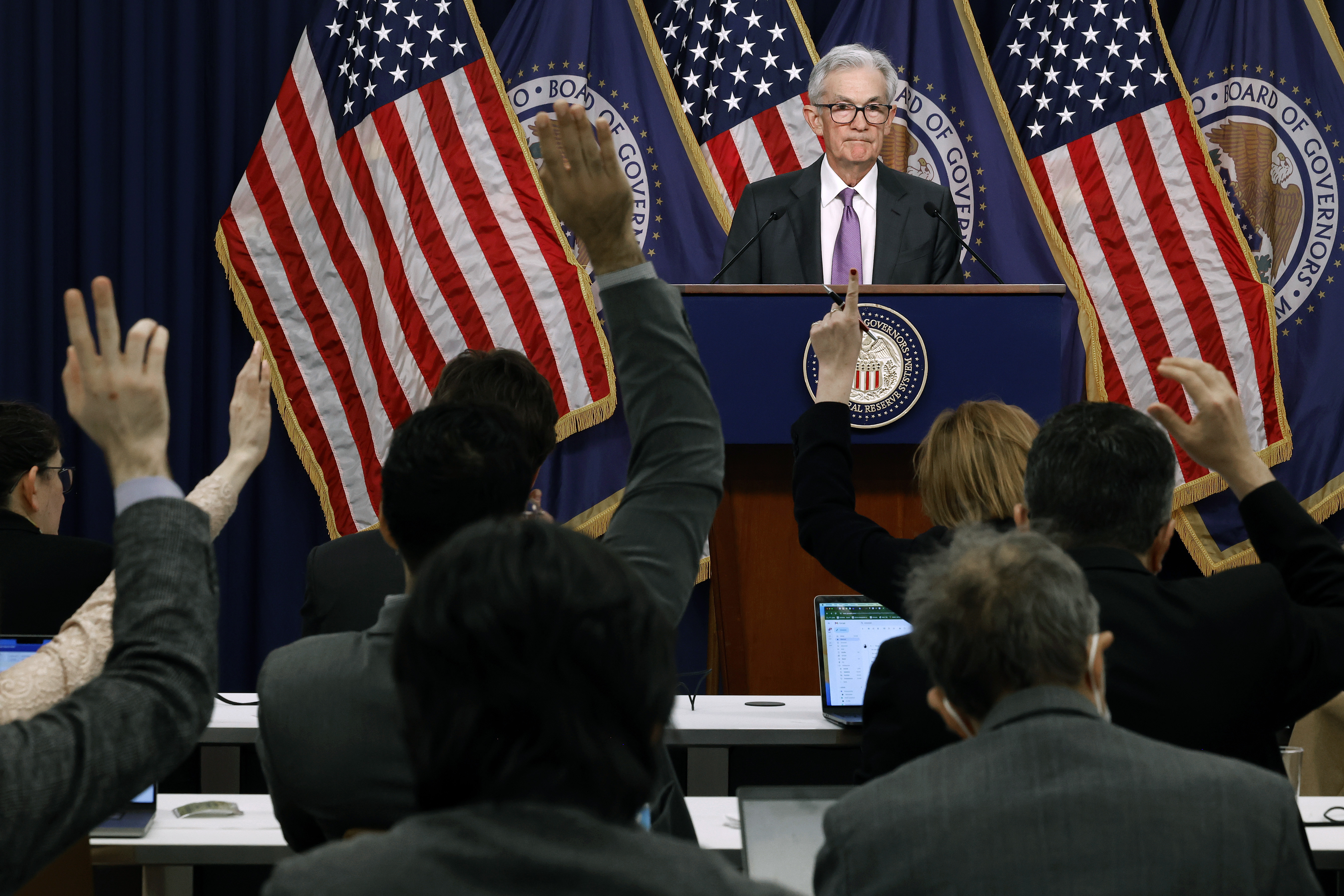 Reporters raise their hands to ask Federal Reserve Chair Jerome Powell questions during a news conference in Washington, DC, on March 20.