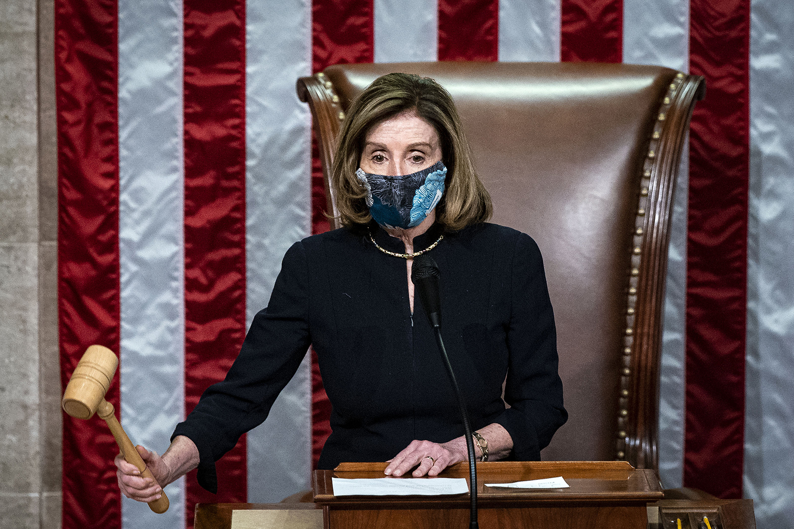US House Speaker Nancy Pelosi, wears a protective mask while banging the Speaker's gavel on the floor of the House at the US Capitol in Washington, DC, on January 13.
