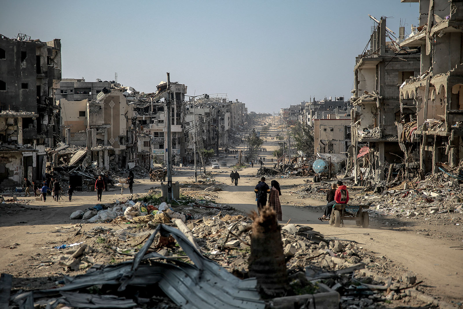 People walk past destroyed buildings in Beit Lahia in northern Gaza on February 26.