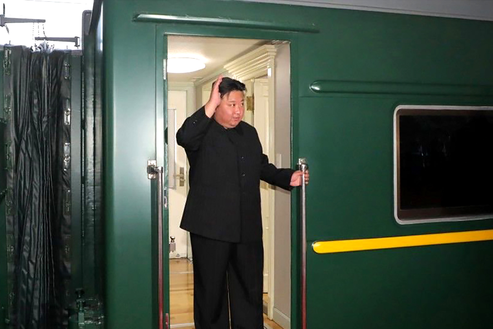 Kim Jong Un waves from a train in Pyongyang, North Korea, as he leaves for Russia.