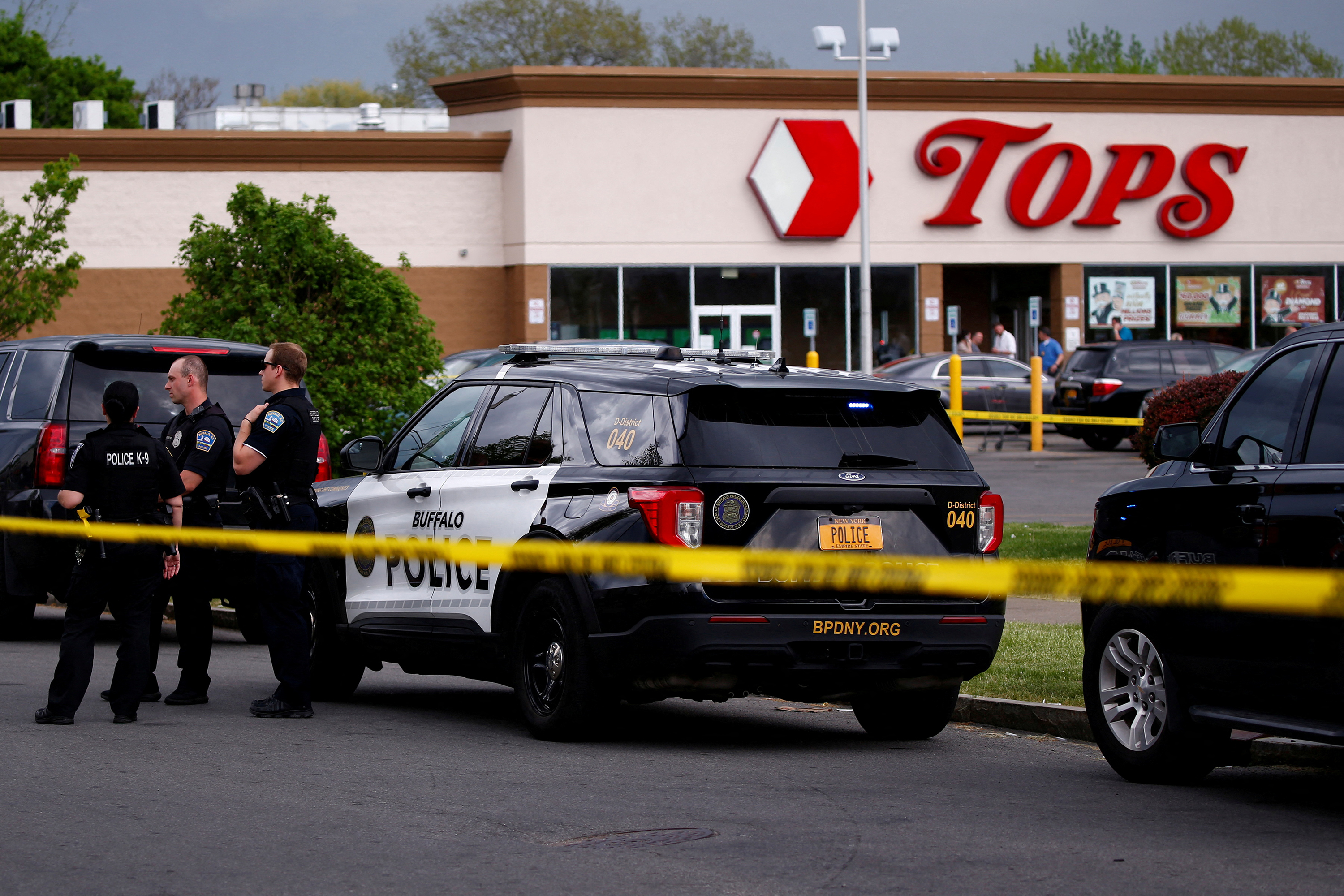 Police officers secure the scene after a shooting at Tops supermarket in Buffalo, New York, on Saturday, May 14. 