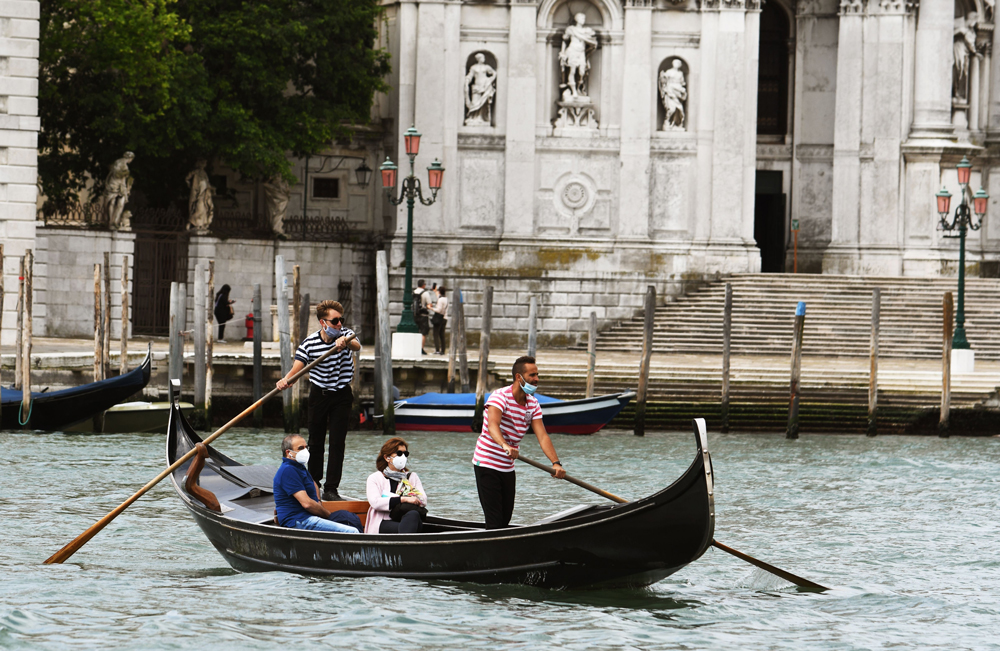 People enjoy a gondola ride on May 30 in Venice, Italy. 