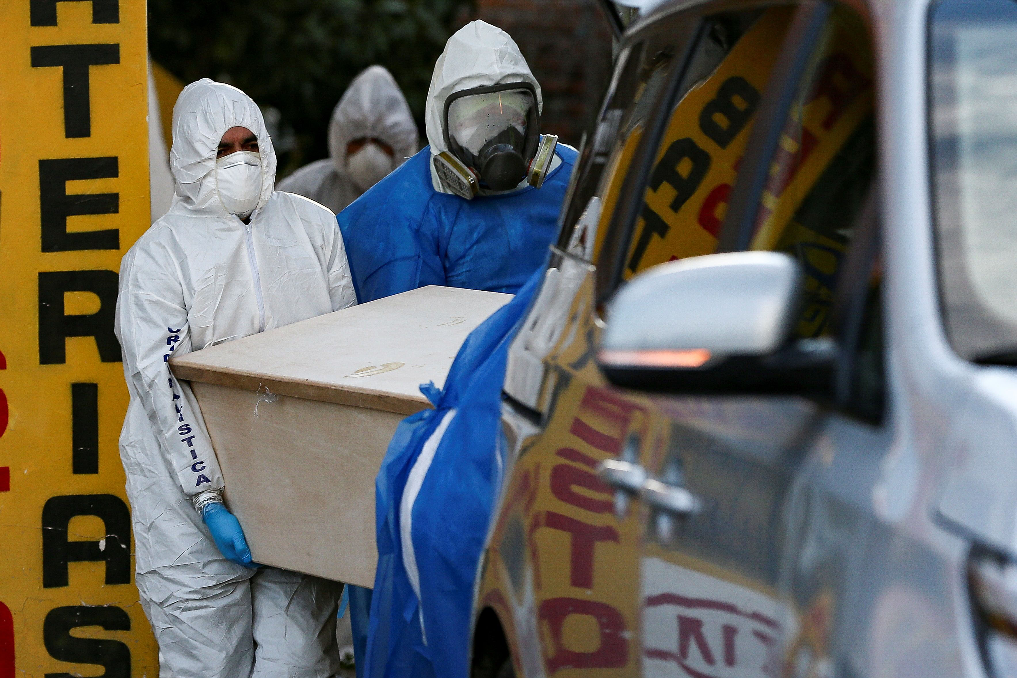 Police and funeral staff remove the body of a person said to have died from Covid-19 in a peripheral neighborhood of Quito, Ecuador, on May 7.
