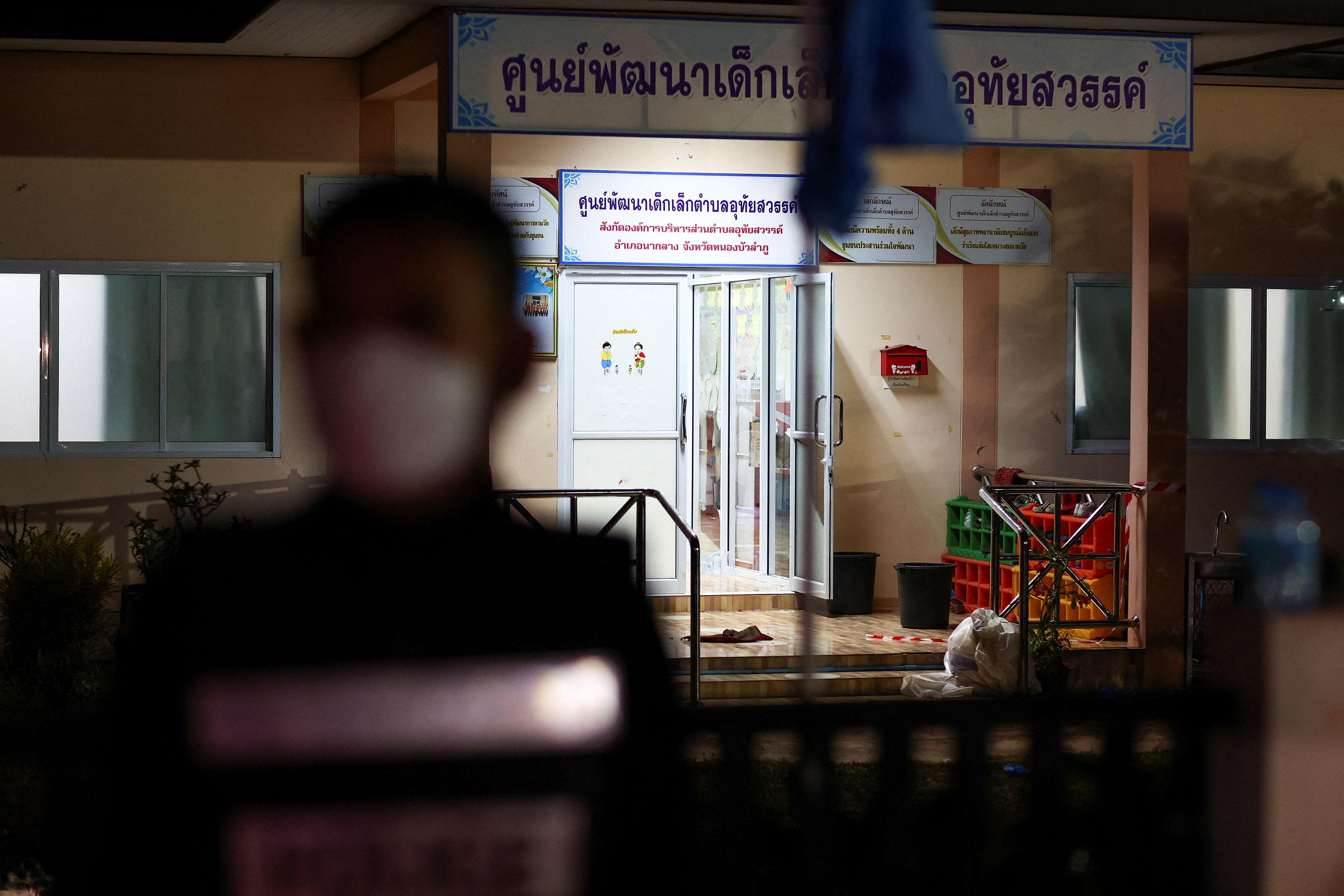 A police officer stands outside the scene of the shooting in the province of Nong Bua Lam Phu, Thailand, on Thursday.