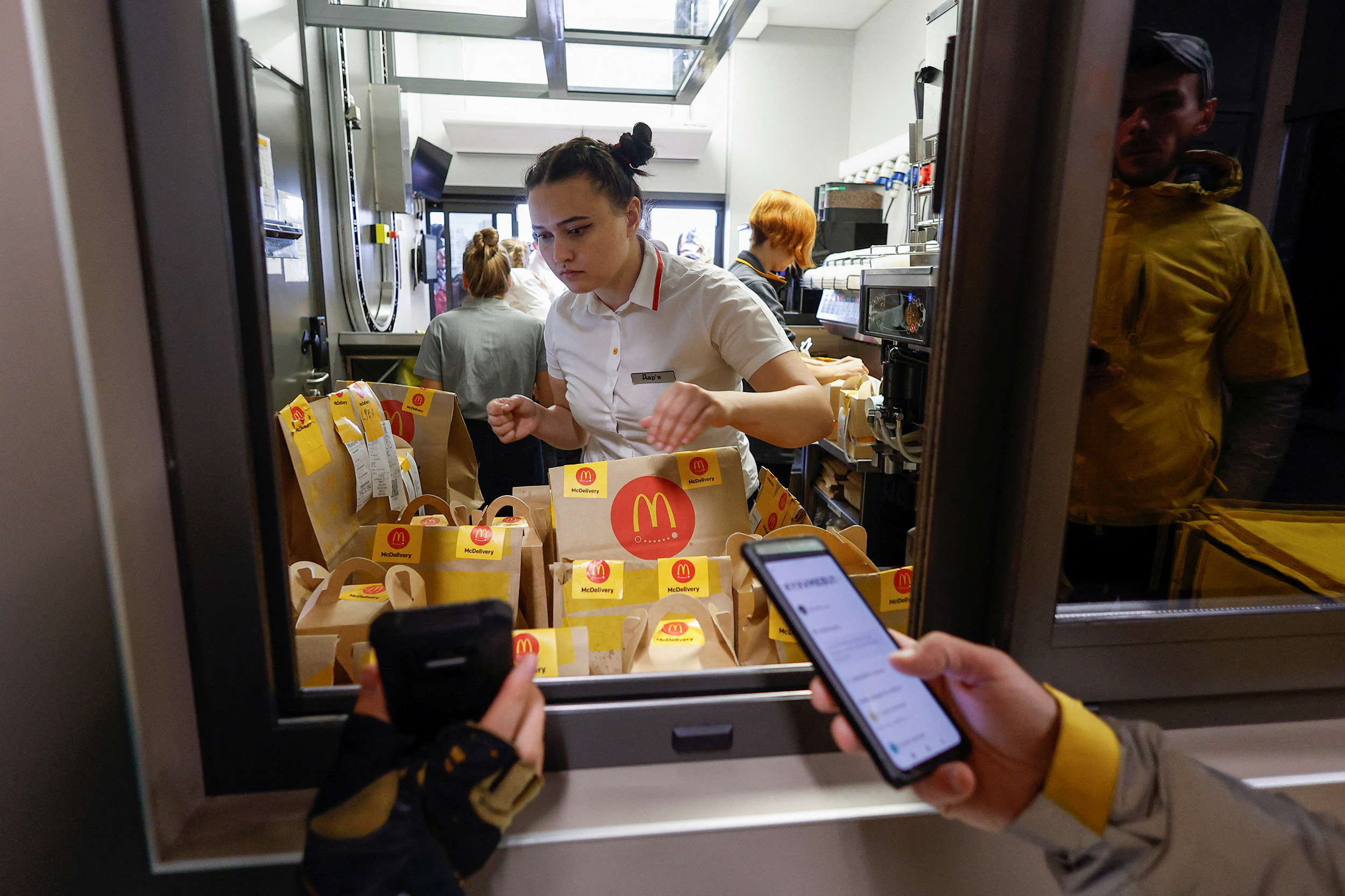 A McDonald's employee checks orders before passing them to Glovo food delivery couriers after the chain reopened in Kyiv, Ukraine, on September 20.