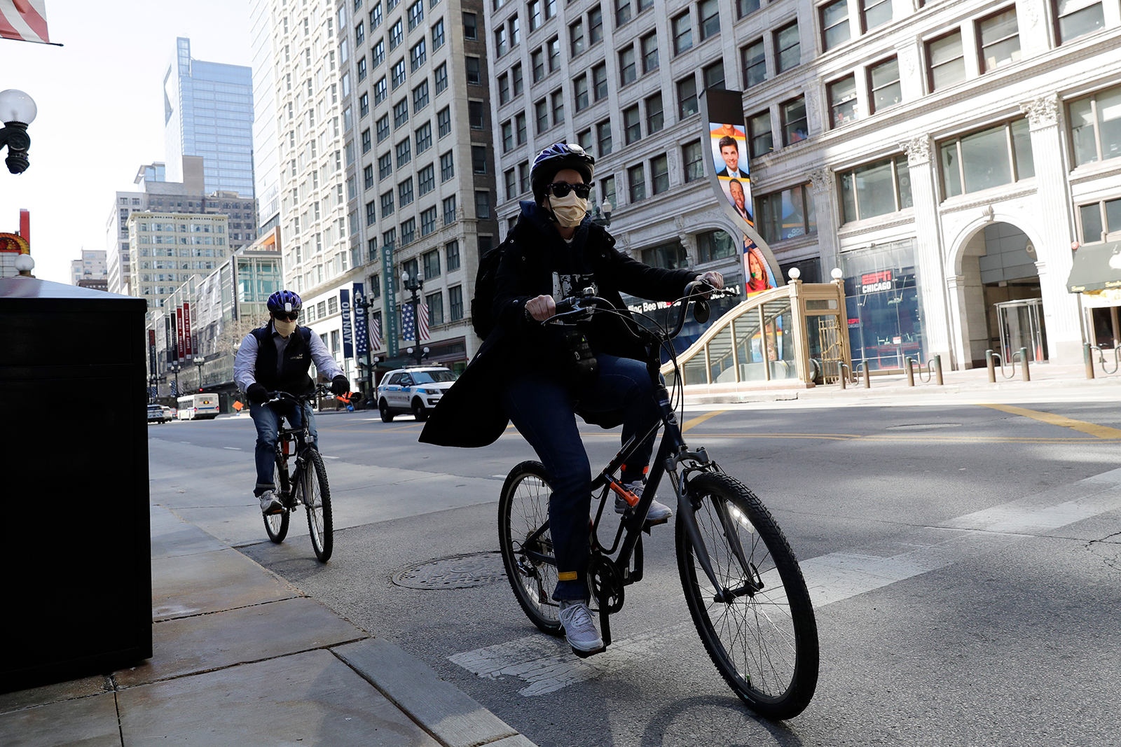 People wear mask as they ride bicycle in downtown Chicago on May 7.