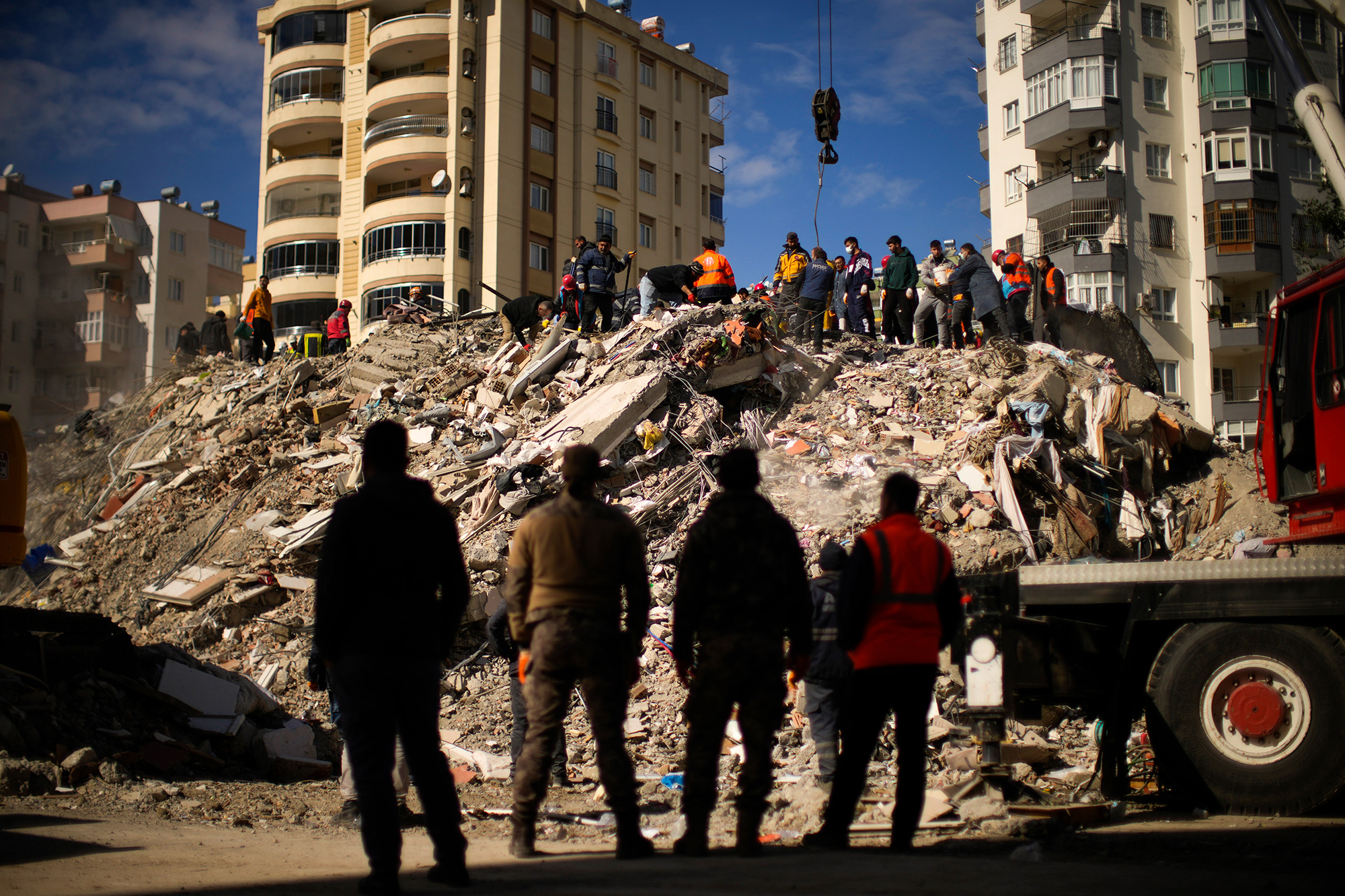 Rescue teams search for people in a destroyed building in Adana, Turkey.