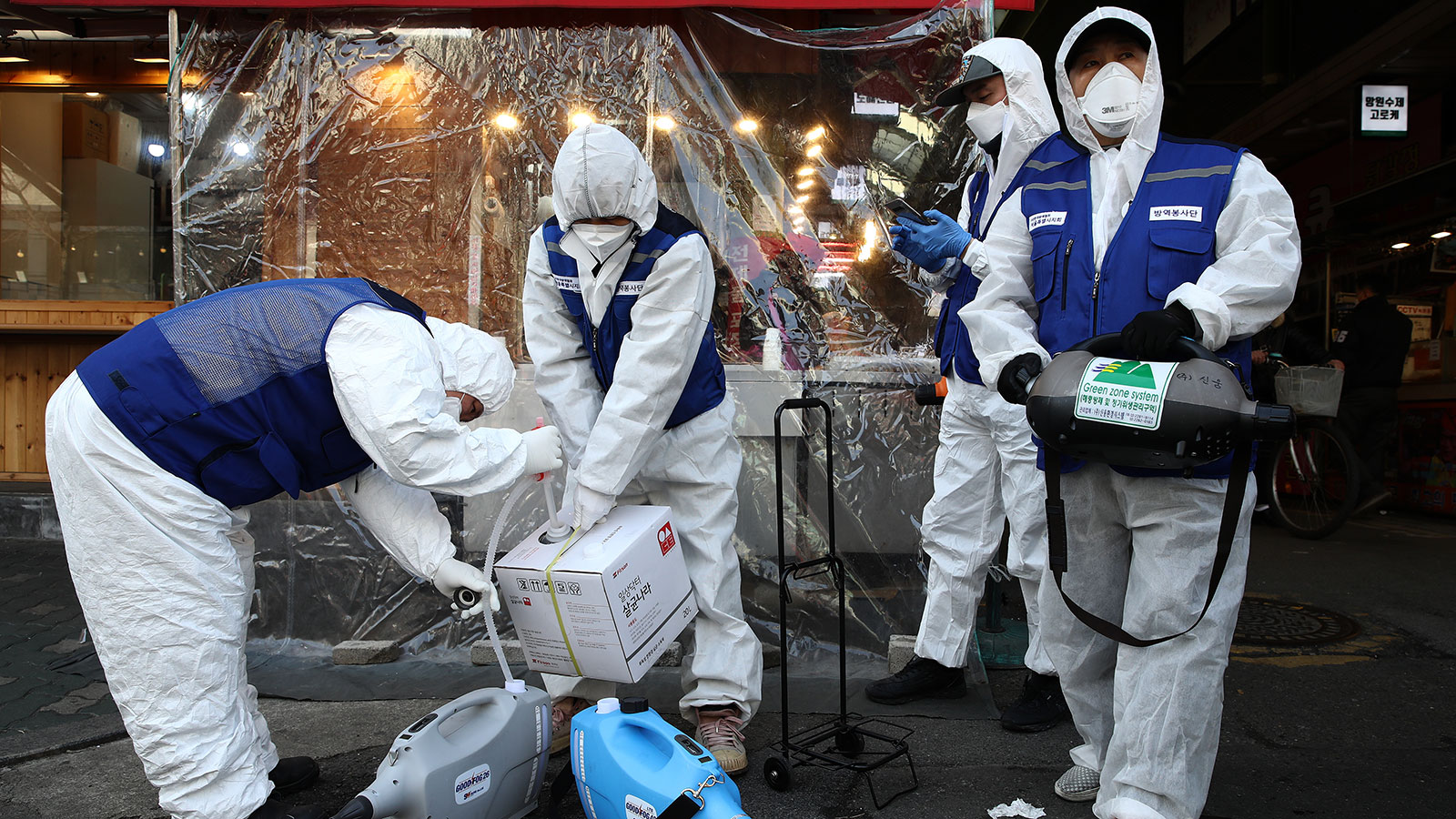 Disinfection workers wearing protective gear prepare to disinfect against the coronavirus at a market in Seoul, South Korea.