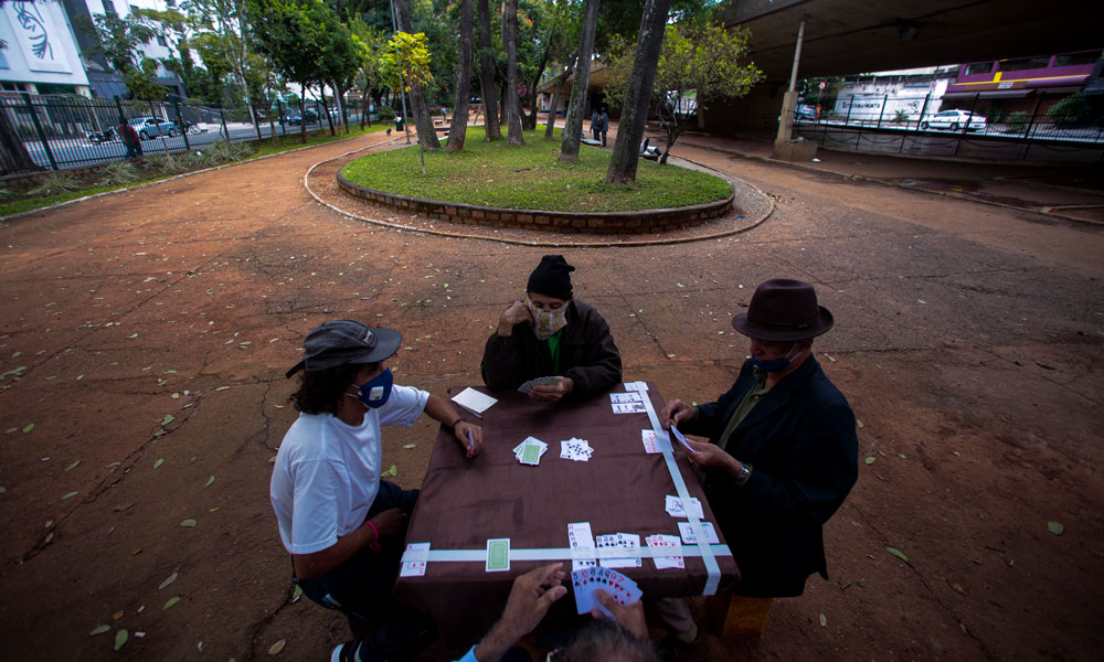  Men wearing face masks playing cards in a square amidst the coronavirus pandemic on May 7, in Sao Paulo, Brazil. 