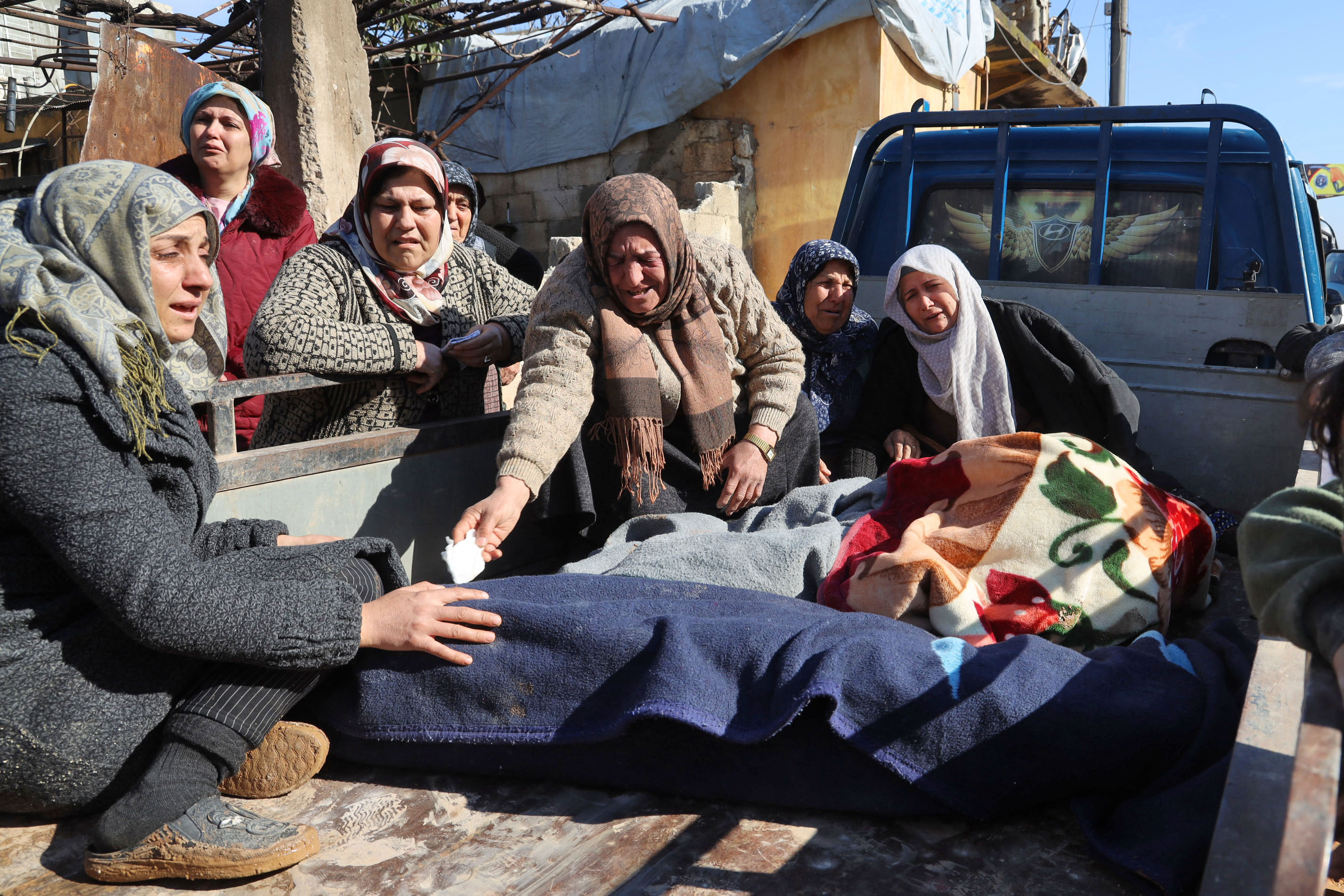 Women mourn next to bodies on the back of a truck in Jandaris, Syria, on Tuesday.