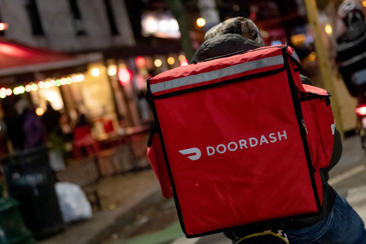 A DoorDash delivery driver waits near a restaurant on December 30, 2020 in New York City.