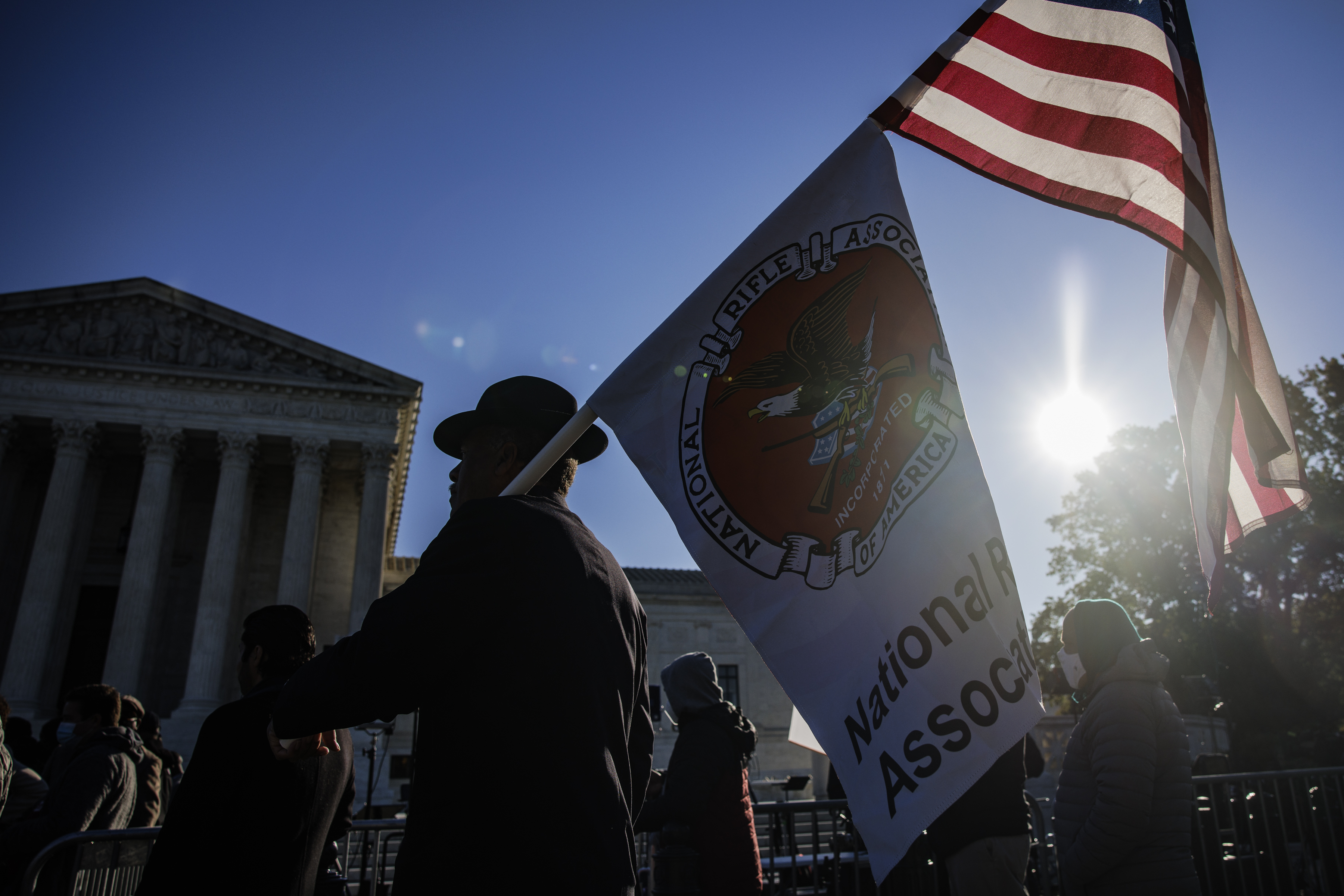 A Second Amendment demonstrator holds American and National Rifle Association (NRA) flags outside the Supreme Court on Wednesday.
