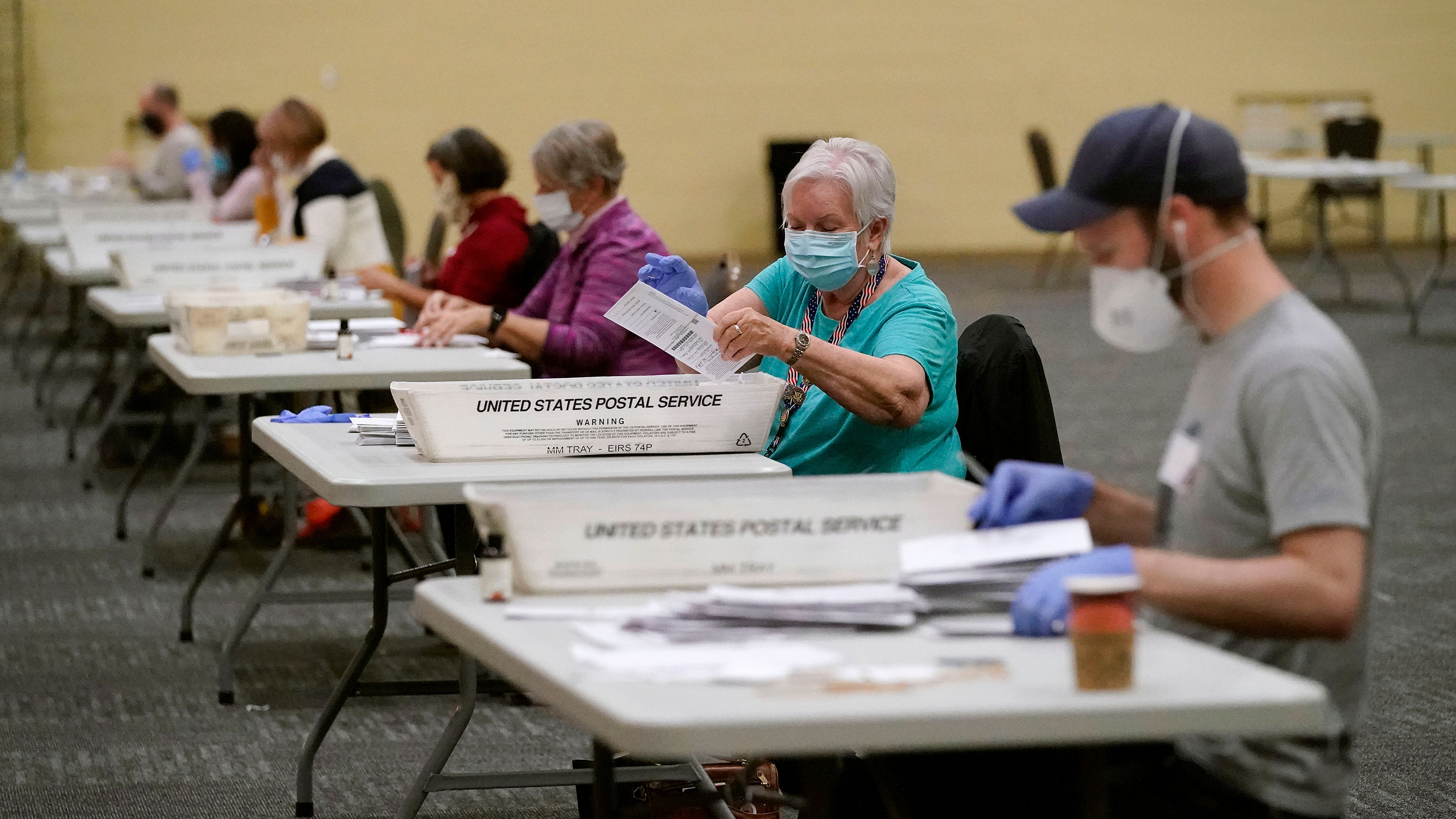 Workers prepare mail-in ballots for counting, Wednesday, Nov. 4, 2020, at the convention center in Lancaster, Pa., following Tuesday's election. (AP Photo/Julio Cortez)
