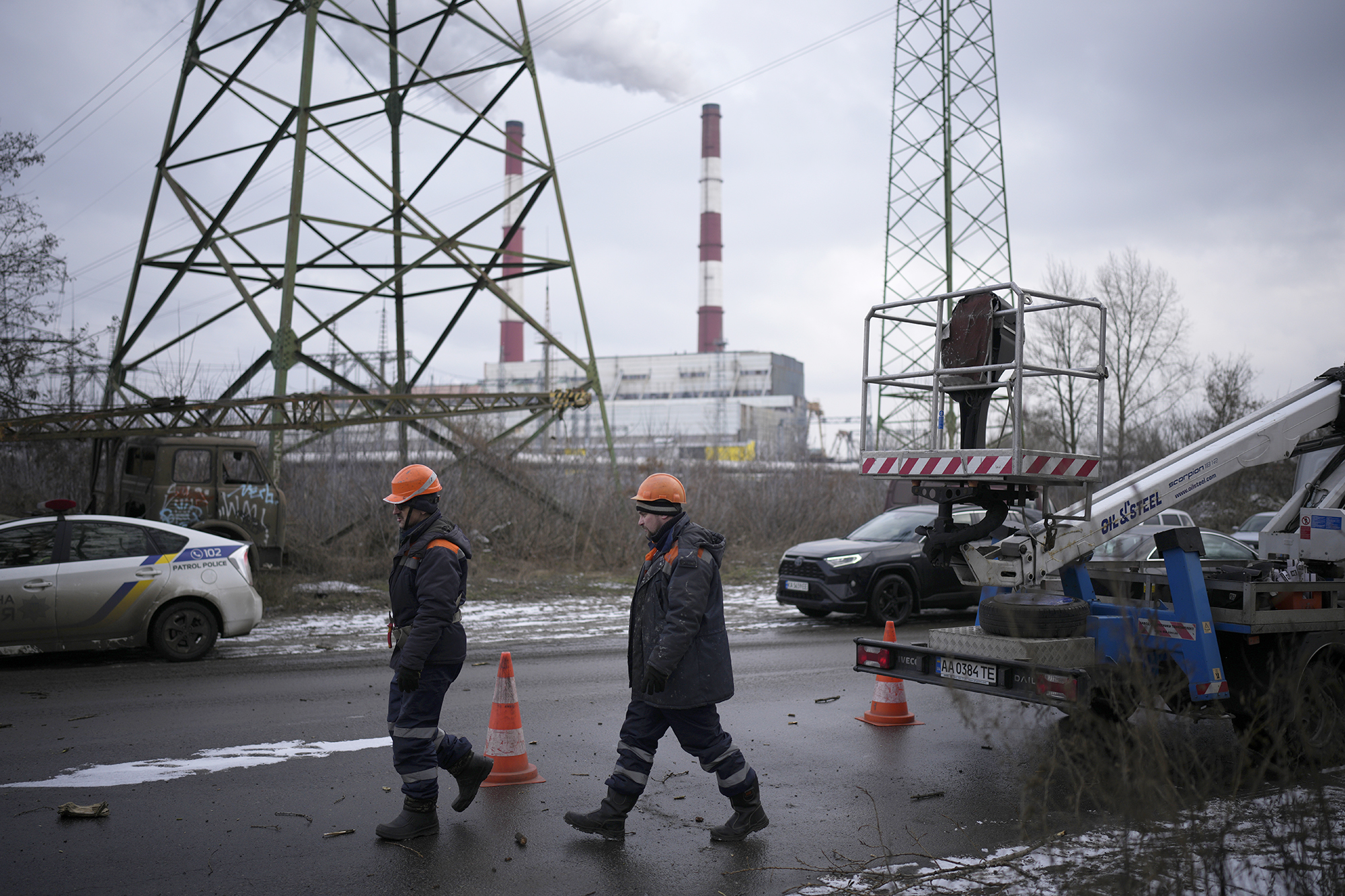 Electrician workers walk next to a power plant after a rocket attack in Kyiv, Ukraine, on January 26.