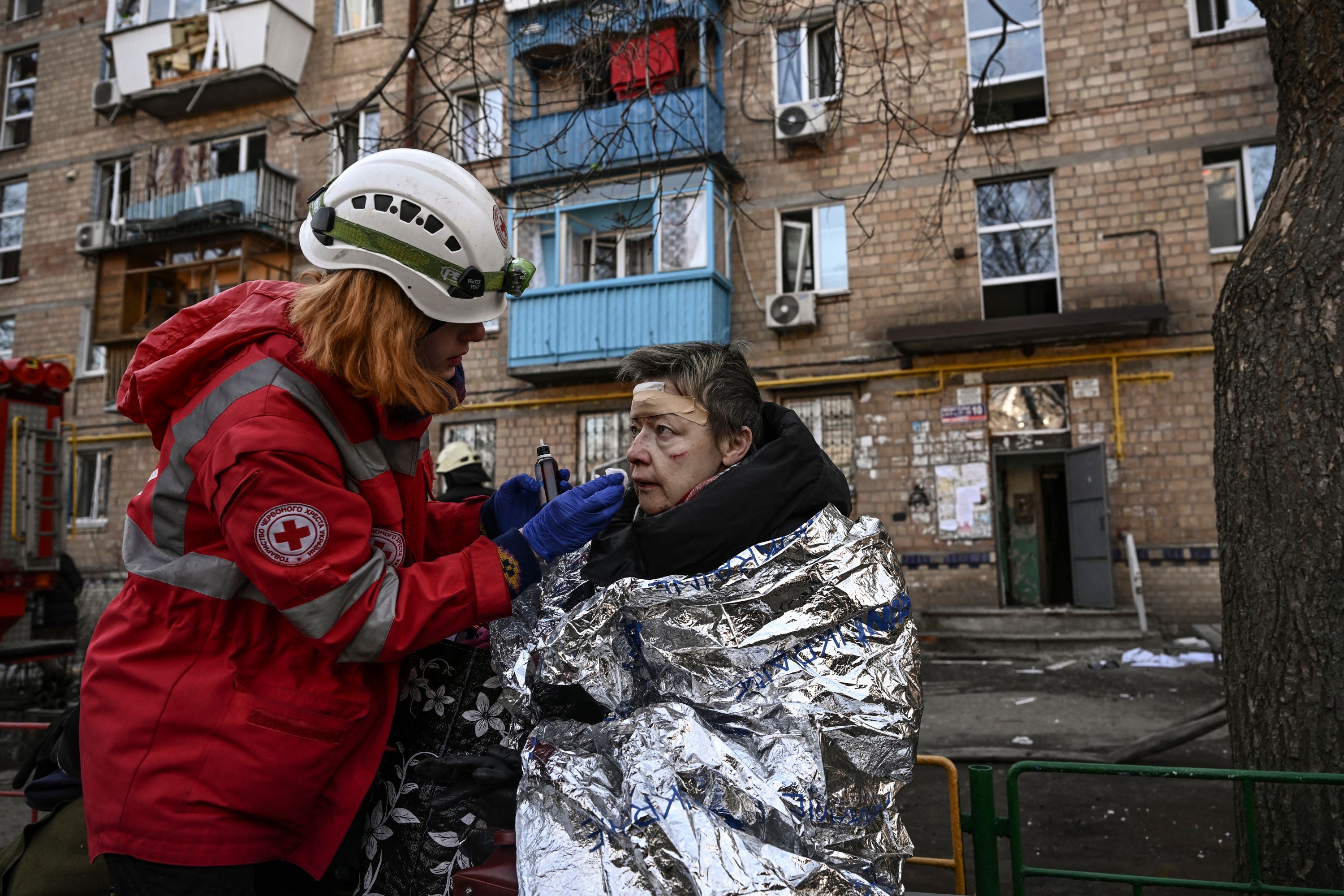An injured woman receives treatment after shelling in a residential area in Kyiv, Ukraine, on March 18.