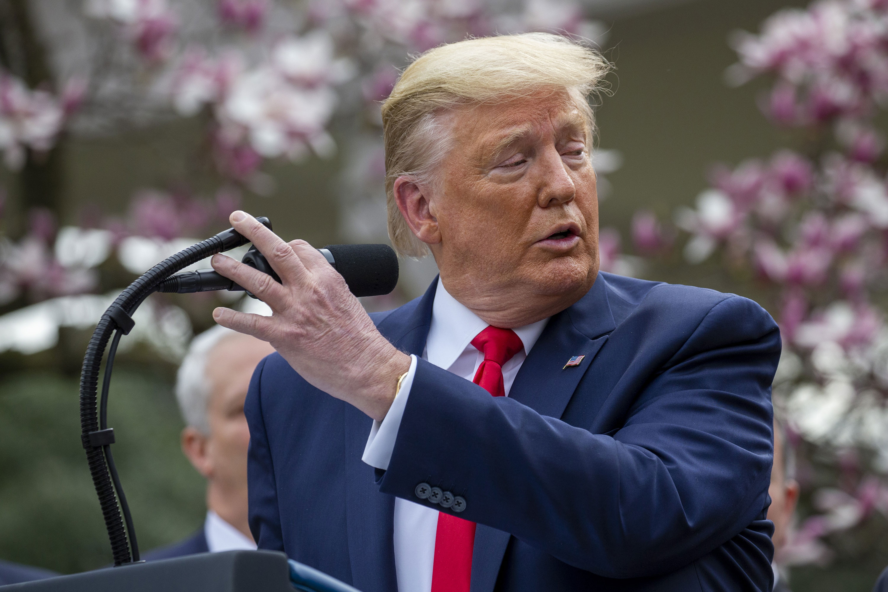 President Donald Trump touches the microphone while speaking at a news conference about Coronavirus in the Rose Garden of the White House on Friday, March 13.