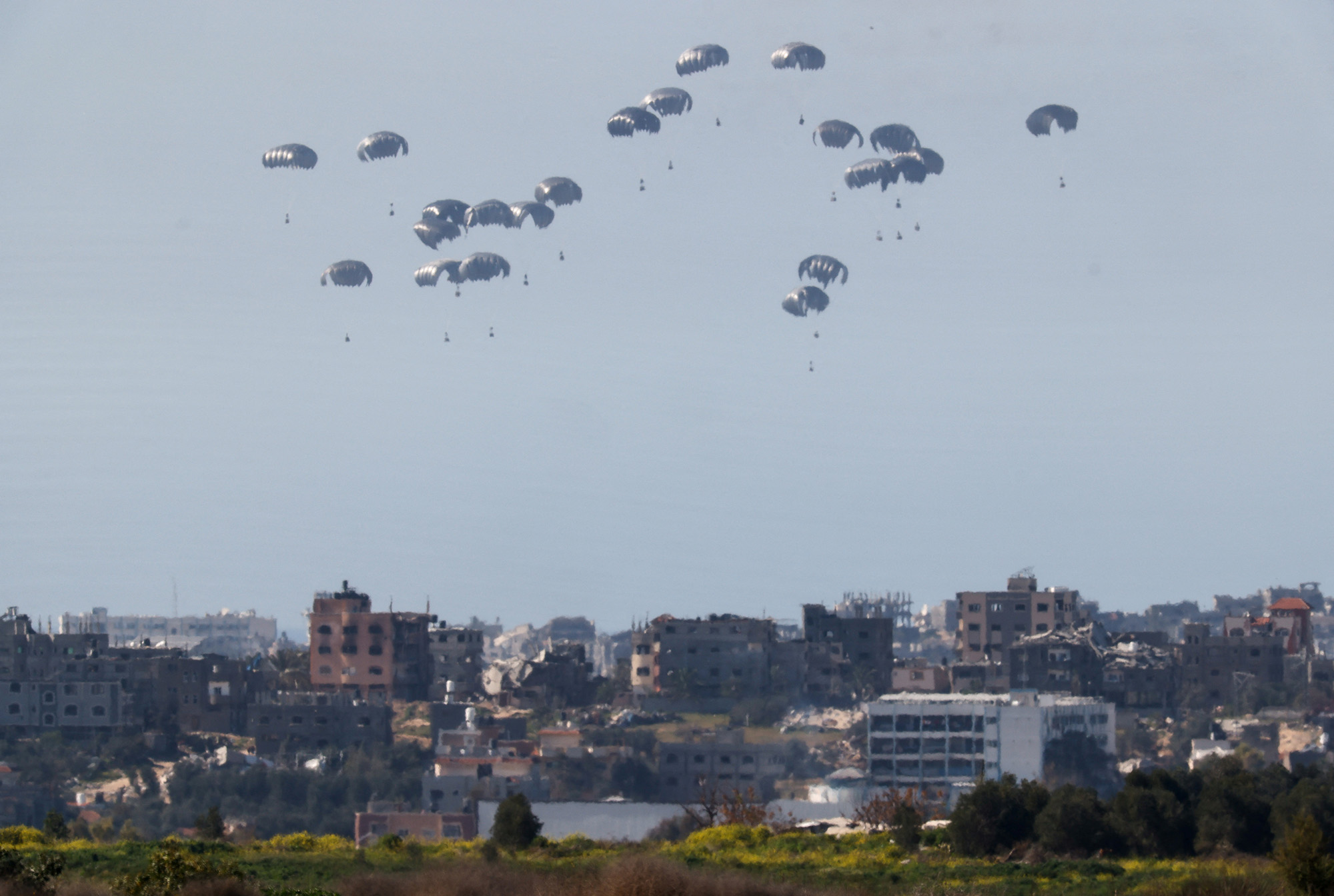Packages fall towards Gaza after being dropped from a military aircraft as seen from southern Israel on March 5.
