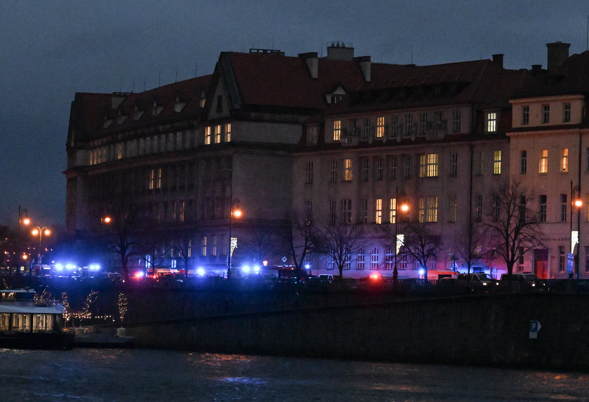 Lights from emergency vehicles are seen along the bank of river Moldau by Charles University in Prague on Thursday.