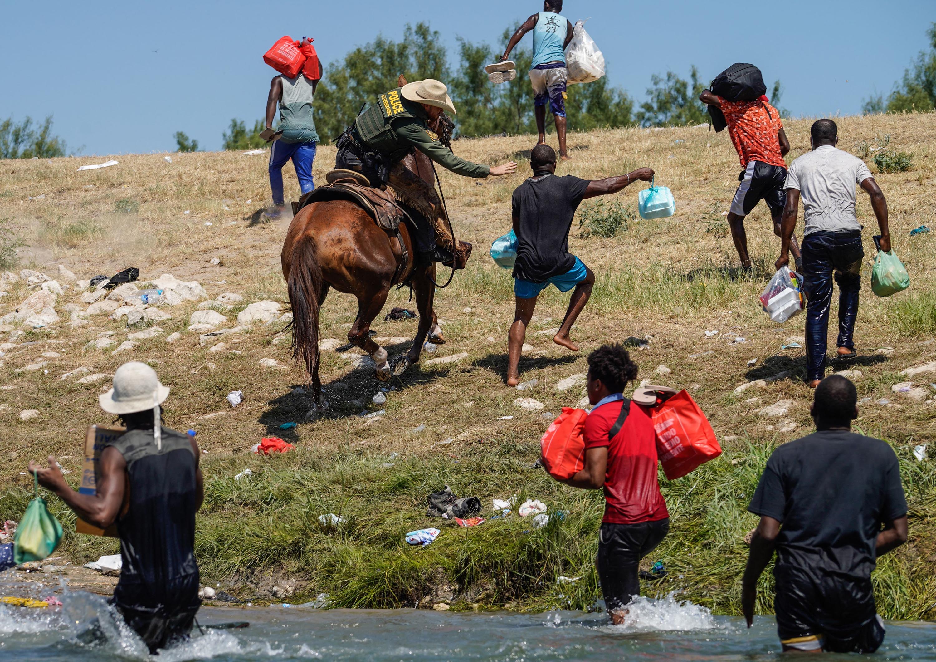 A United States Border Patrol agent on horseback tries to stop a Haitian migrant from entering an encampment on the banks of the Rio Grande near the Acuna Del Rio International Bridge in Del Rio, Texas on September 19, 2021.