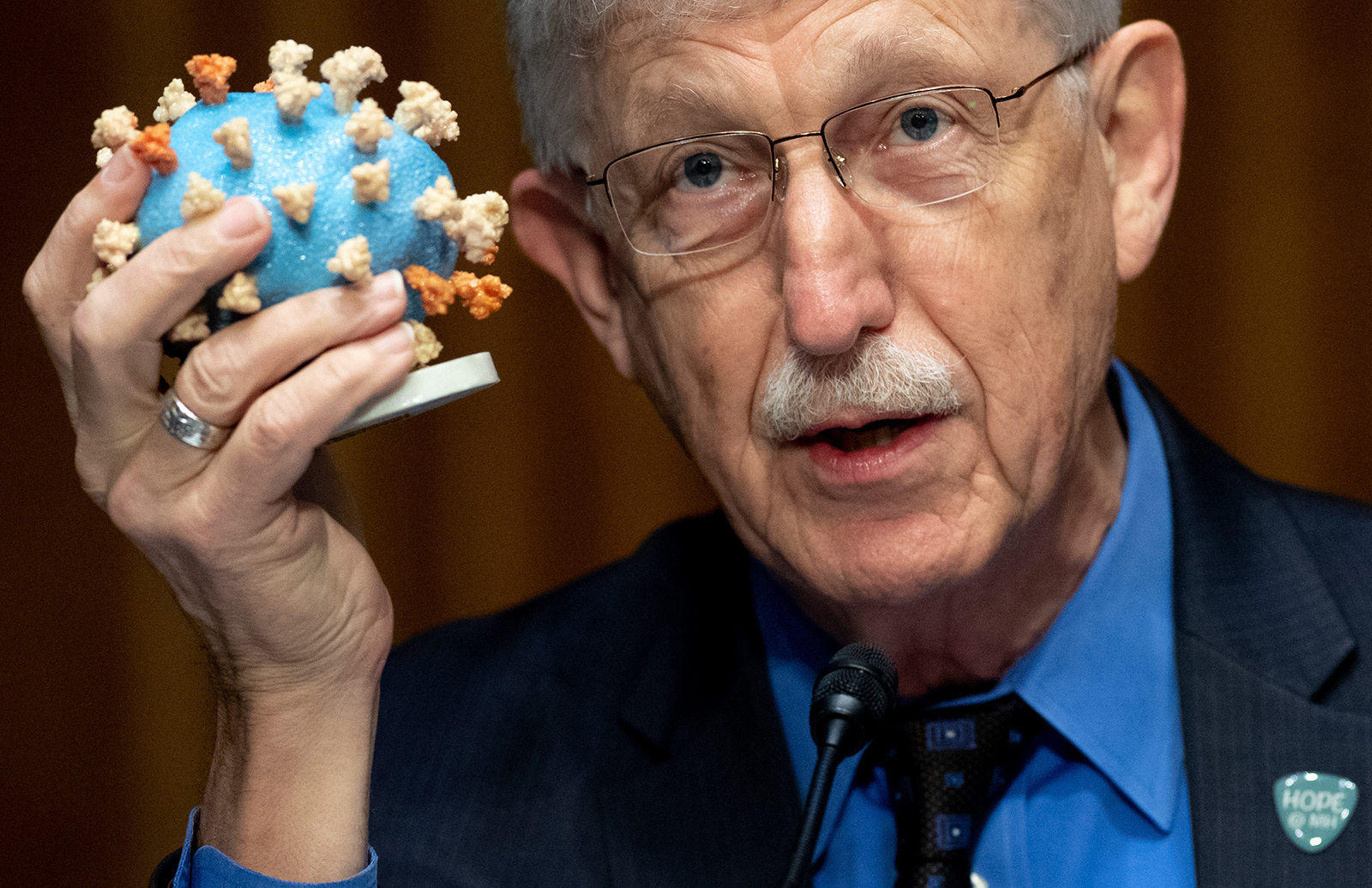 Dr. Francis Collins holds up a model of the coronavirus on Capitol Hill on July 2.
