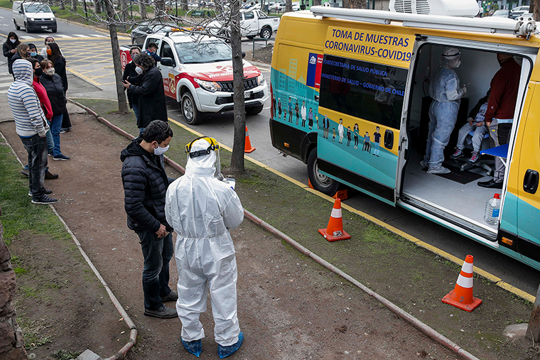 People queue outside a Health Ministry van to be tested for COVID-19 in Santiago, Chile, on July 10.