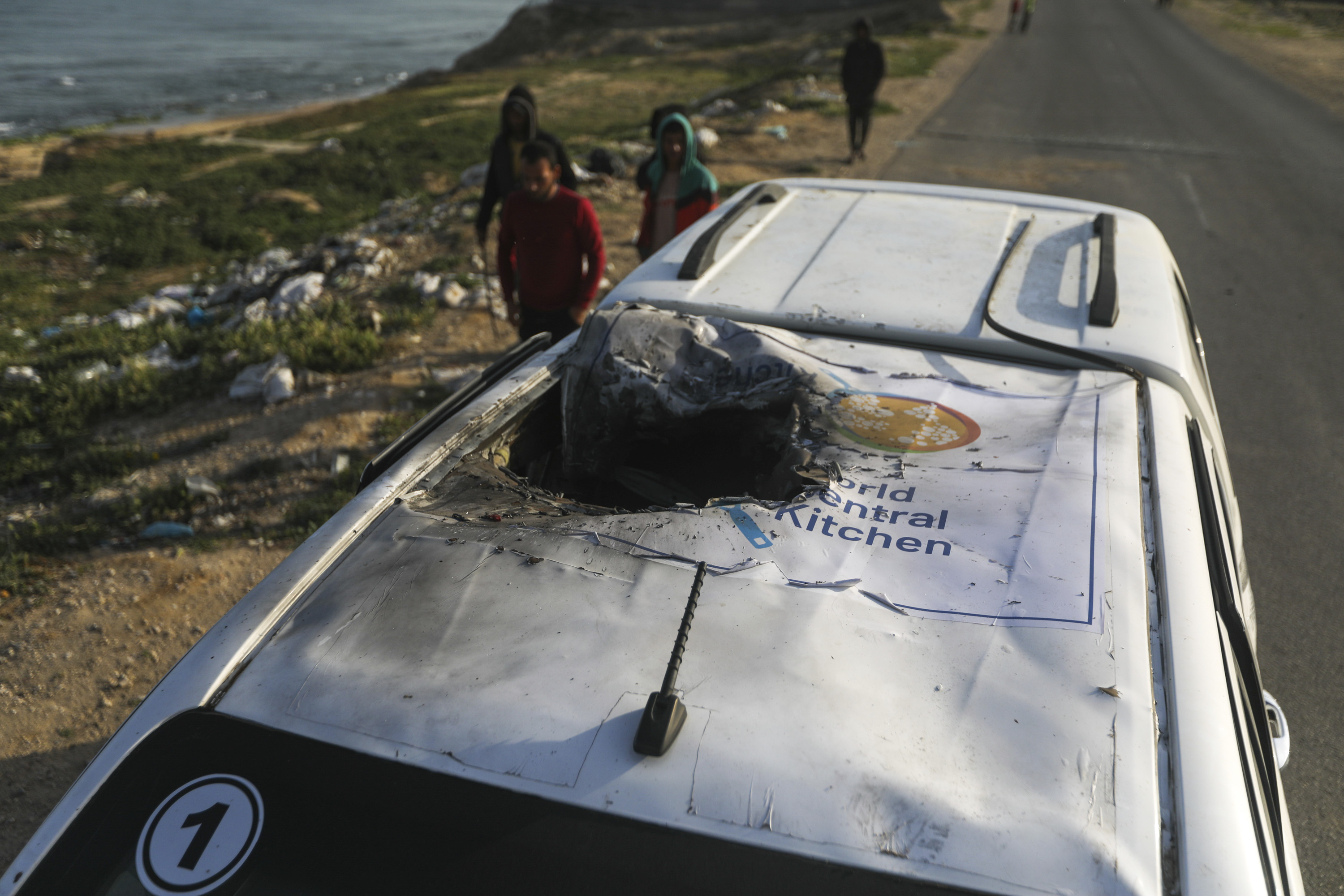 People inspect a vehicle with a logo of World Central Kitchen after it was hit by an Israeli airstrike in Deir al-Balah, Gaza, on Tuesday, April 2. 