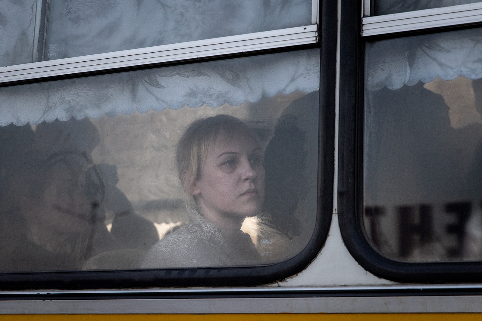 A woman looks out the window of a bus after a large convoy of cars and buses arrived at an evacuation point, carrying hundreds of people evacuated from Mariupol and Melitopol on March 25, in Zaporizhzhia, Ukraine. 